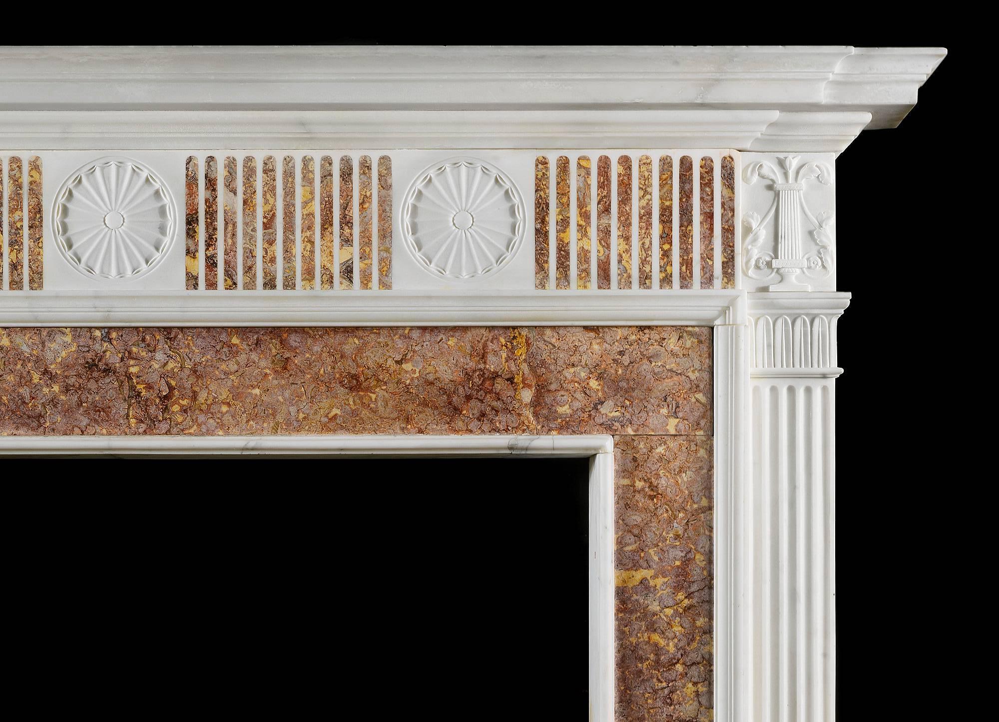A late 18th century antique fireplace mantel in Statuary and Spanish Brocatelle marble. The breakfront shelf over a frieze with inlaid Brocatelle marble fluting, interspersed by delicate rosette paterae in statuary marble, flanked by florally carved