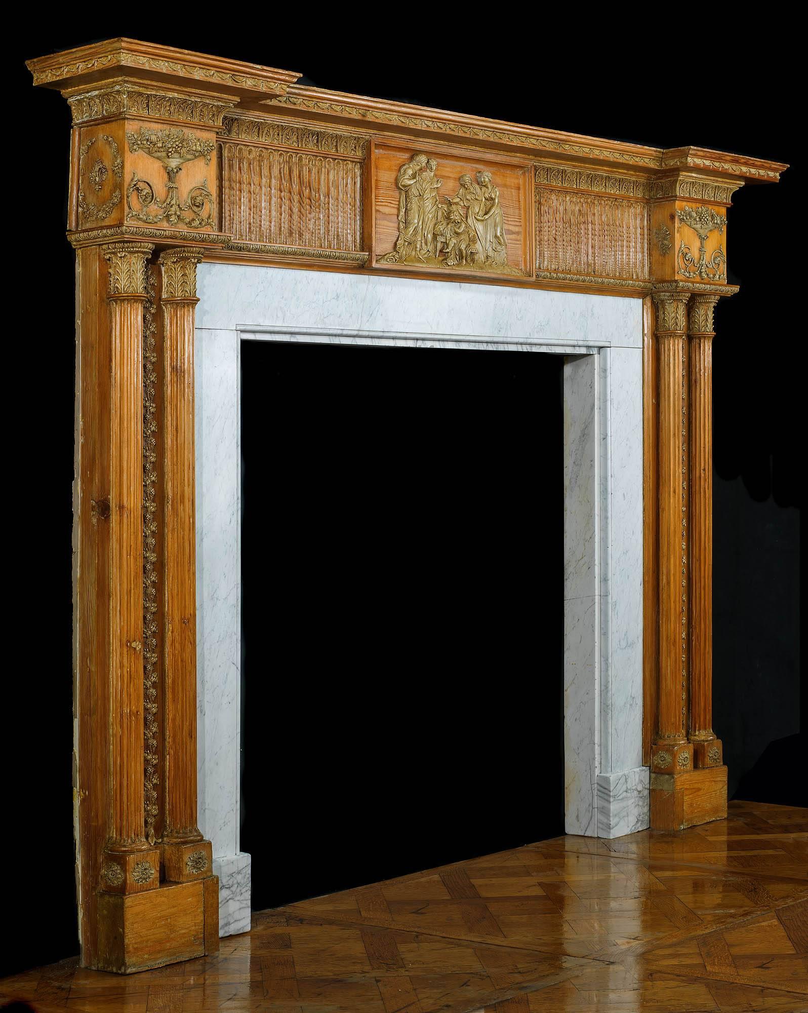 A grand and large George III twin columned warm toned pine and gesso Georgian chimneypiece with its original Carrara marble slips. The fluted and athemion decorated frieze is centred by a plaque depicting four Classical Greek figures around a