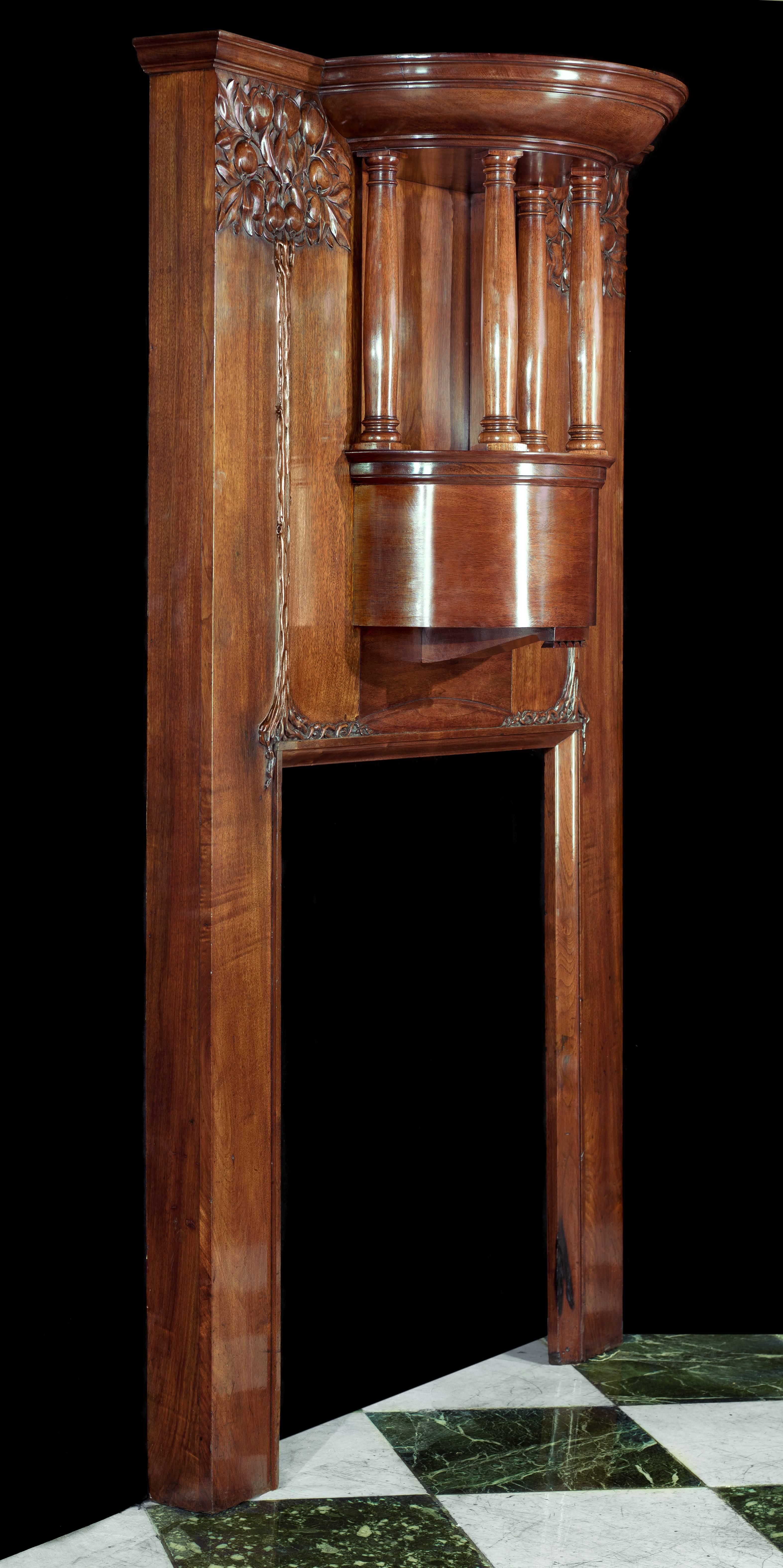 A tall and elegant walnut antique Art Nouveau fireplace in the manner of Charles Harrison Townsend (1851-1928), architect and designer of the 1901 Horniman Museum and the 1895 Bishopsgate Institute, both in London. Carved in relief in a design