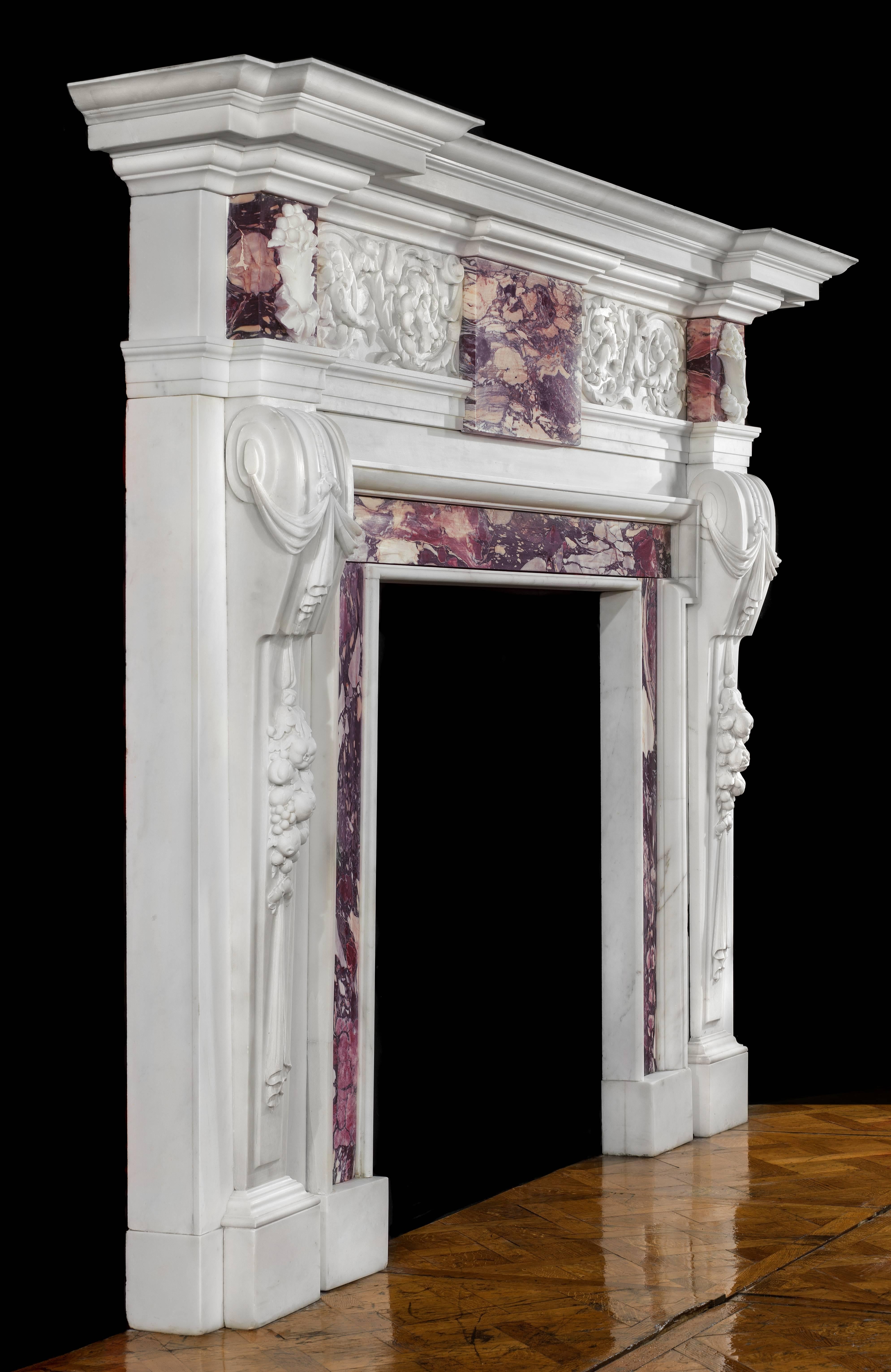 A large and fine antique Palladian style chimneypiece in the manner of William Kent (1685-1748). Carved in pure white Statuary Marble and with Breche Violette endblocks and ingrounds, it has a prominent corniced shelf set over a beautifully scrolled