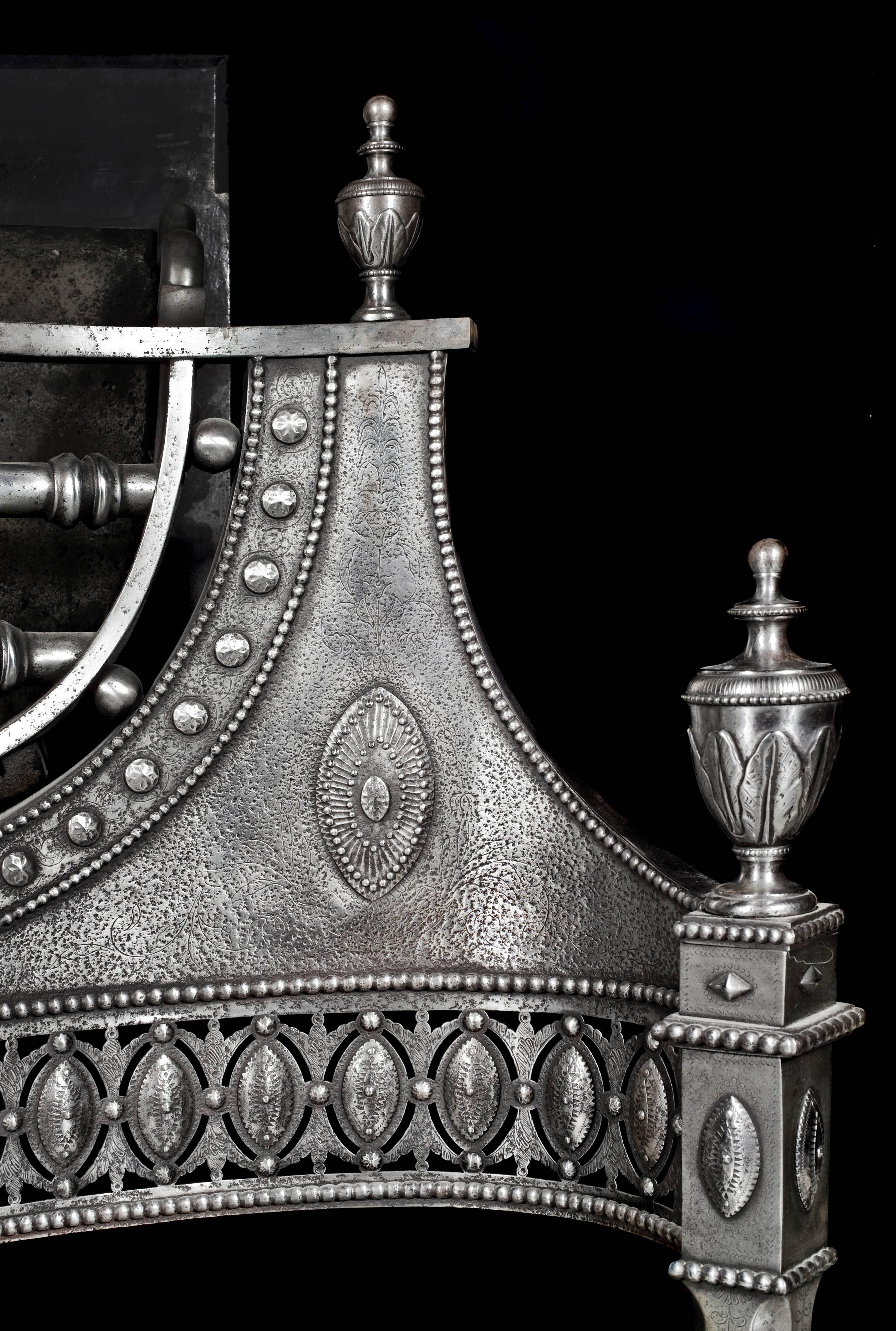 A rare and important pierced, etched and engraved steel George III antique fire grate. It is made in bright cut steel with very finely etched and engraved foliate and acanthus designs, applied beading, a skirt of lozenge cut paterae and with lidded