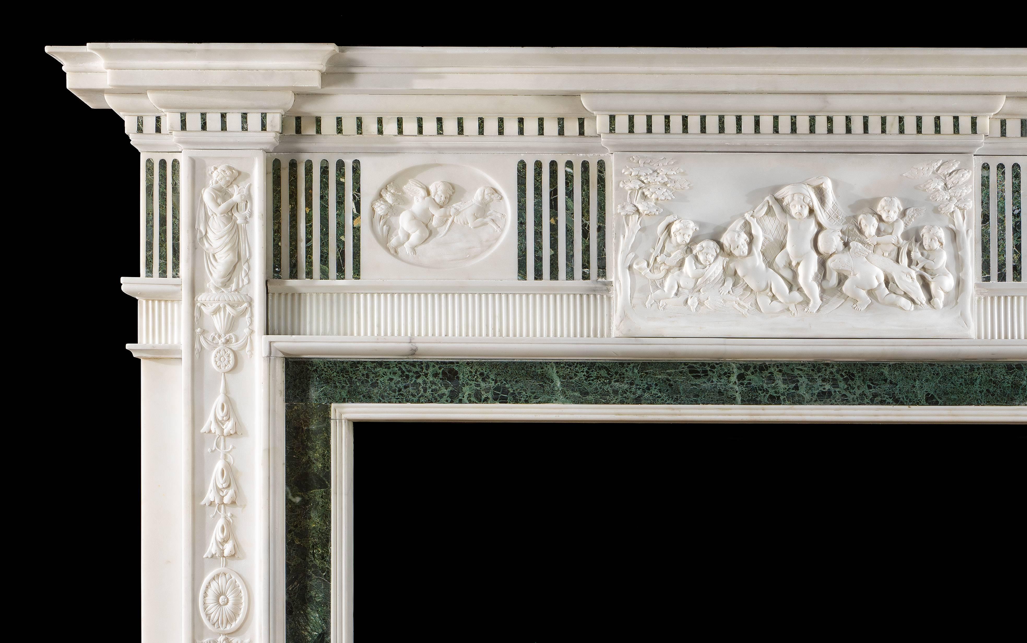 A fine early 20th century Georgian style statuary marble chimneypiece with Verde Antico inlay. The moulded dentil cornice shelf is set above an inlaid fluted frieze with a central tablet of cavorting cherubs flanked by oval panels of hunting cherubs