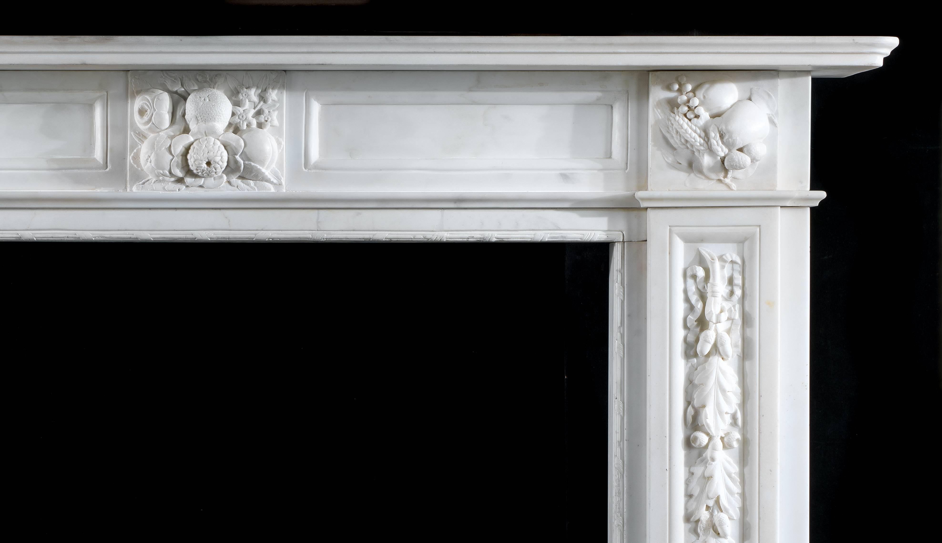 An antique white statuary marble Victorian fireplace surround. The deeply carved central plaque, set beneath the simple moulded shelf on a plain paneled frieze, is decorated with roses, fruit and orange blossom and is flanked by carved end blocks,