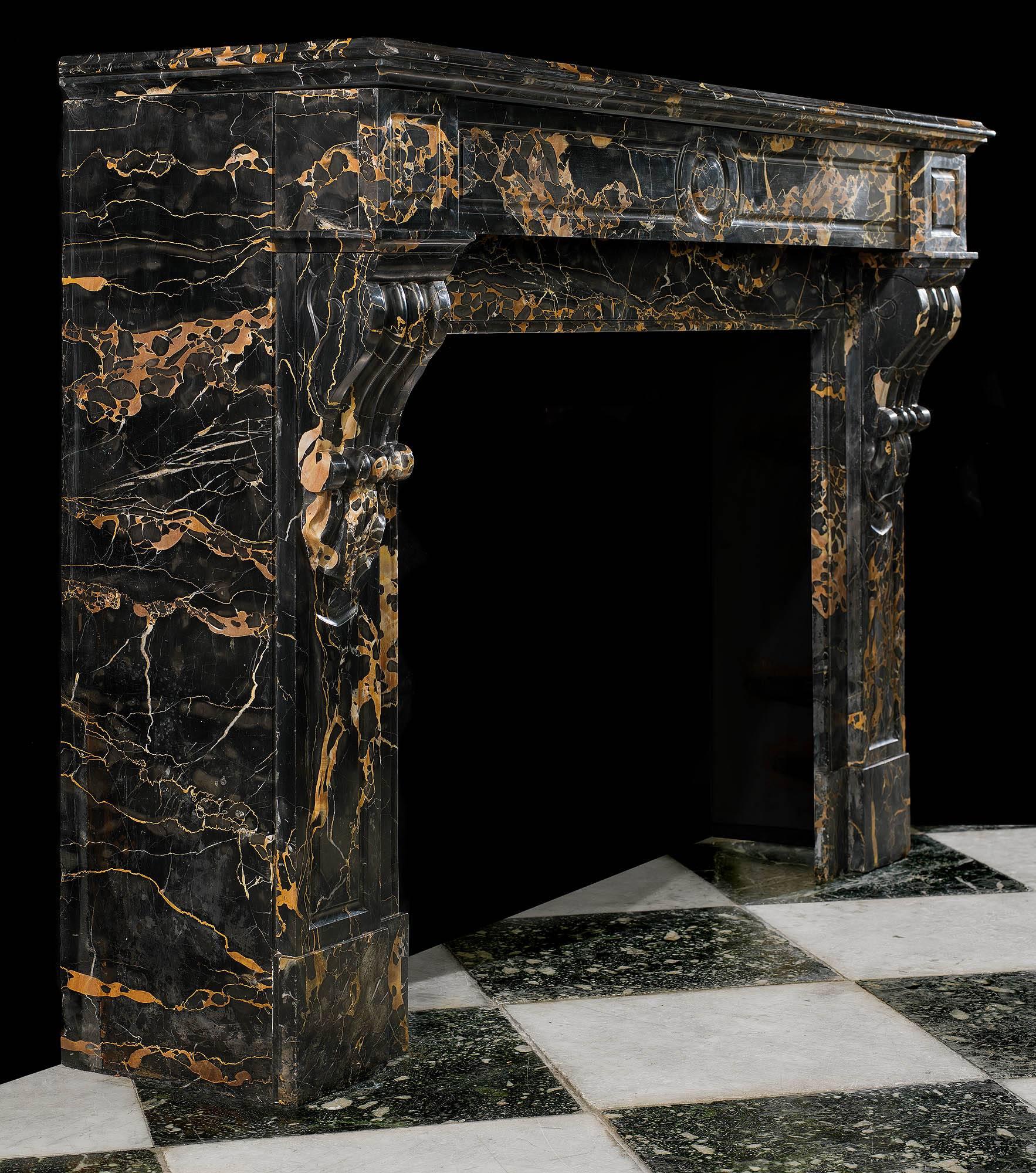 A fine Louis XVI style antique fireplace mantel in rare beautifully gold veined Portoro marble. The moulded rectangular shelf is set above a simple panelled frieze which is flanked by a pair of square endblocks supported on moulded and fluted