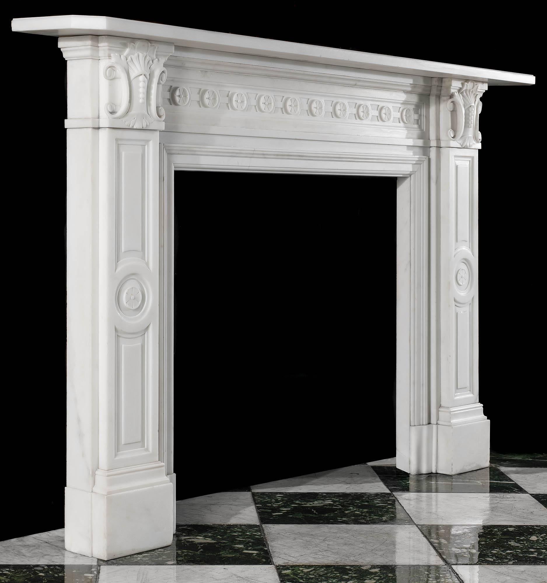A smart Victorian white statuary marble carved antique chimneypiece with a simple bevelled edged shelf above a linked rosette panel on the frieze flanked by scrolled cartouche on the endblocks set above panelled jambs, each centred by a rosette,