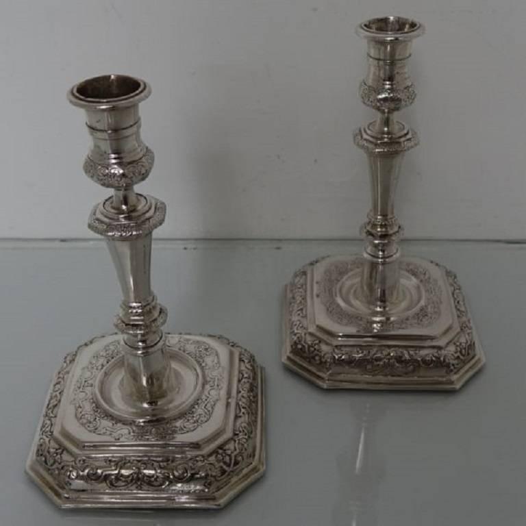 A very rare and highly collectable pair of 18th century octagonal sheet silver candlesticks with elegant contemporary hand embossed bases and sunken in wells. The stems of the candlesticks are stylishly formed and are crowned with a delightful