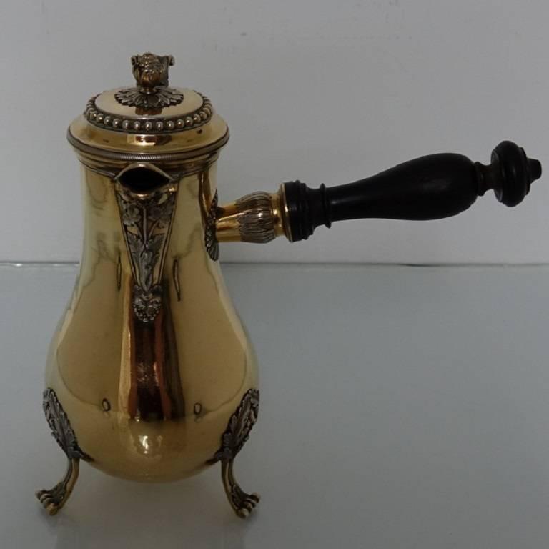 A very elegant 19th century silver gilt side handled coffee pot standing on three ornate feet. The lid is hinged with a gallery of bead decoration for highlights and is crowned with a stunning acorn finial. The handle is beautifully spun out of