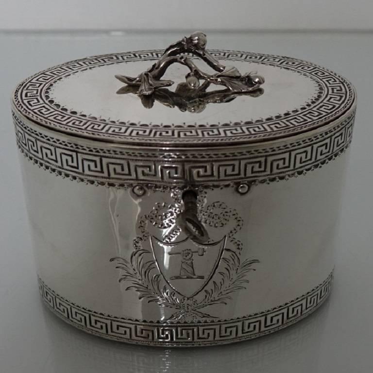 A very elegant oval 18th century tea caddy with a central contemporary crest set inside a shield surrounded by ornate bright cut decoration. Above and below this is a stylish Greek key gallery for highlights/lowlights. The lid is hinged with a