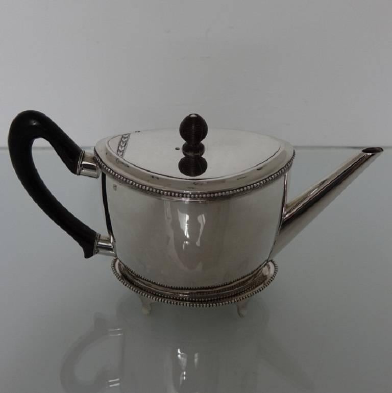 A very elegant oval 19th century Dutch teapot on stand. The teapot is plain formed in design with a upper and lower bead border for decorative highlights. The lid of the teapot is flush hinged and has a band of elegant contemporary engraving. The