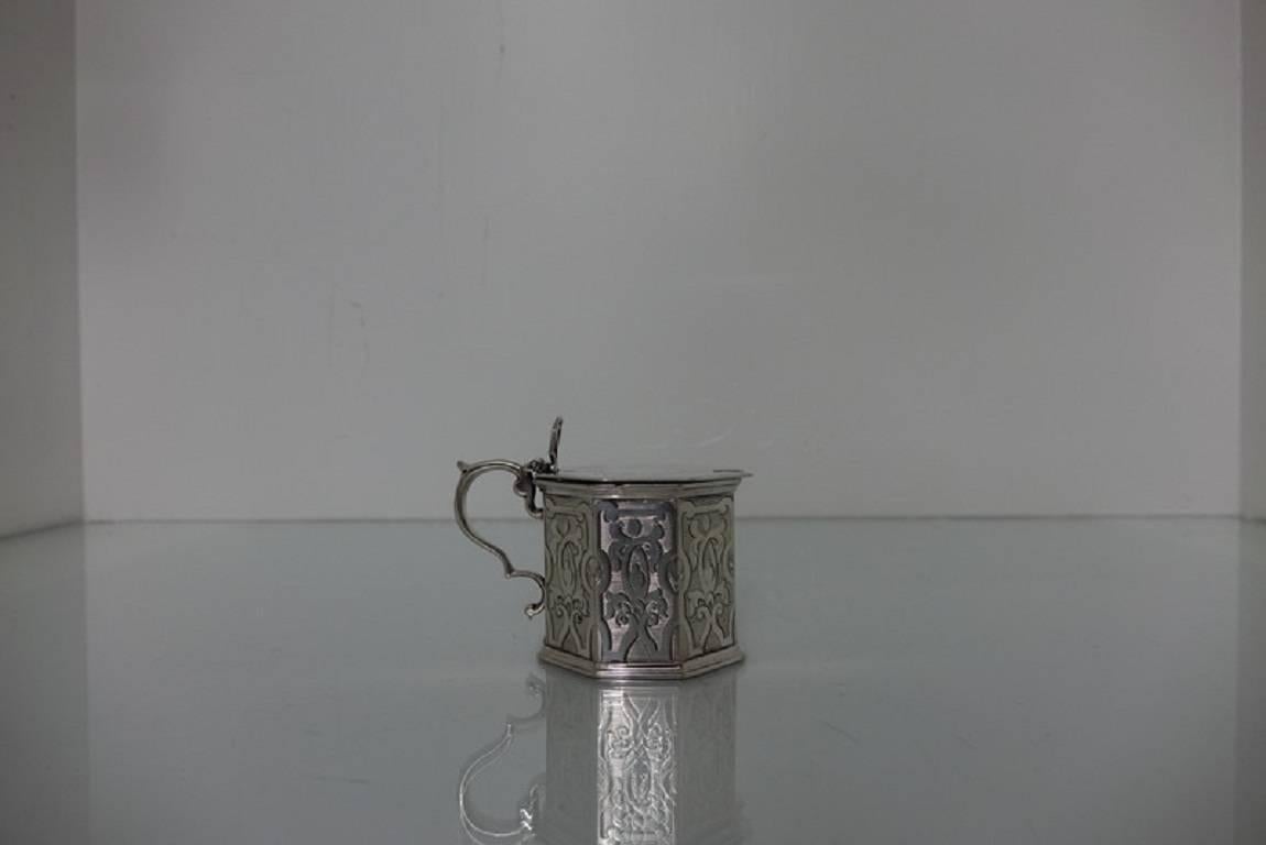 A very elegant 19th century exceptional quality octagonal mustard pot with scroll handle. The body and lid has beautiful bright cut hand engraving for decoration. The lid is hinged with an ornate thumb piece for added highlights. The mustard pot has
