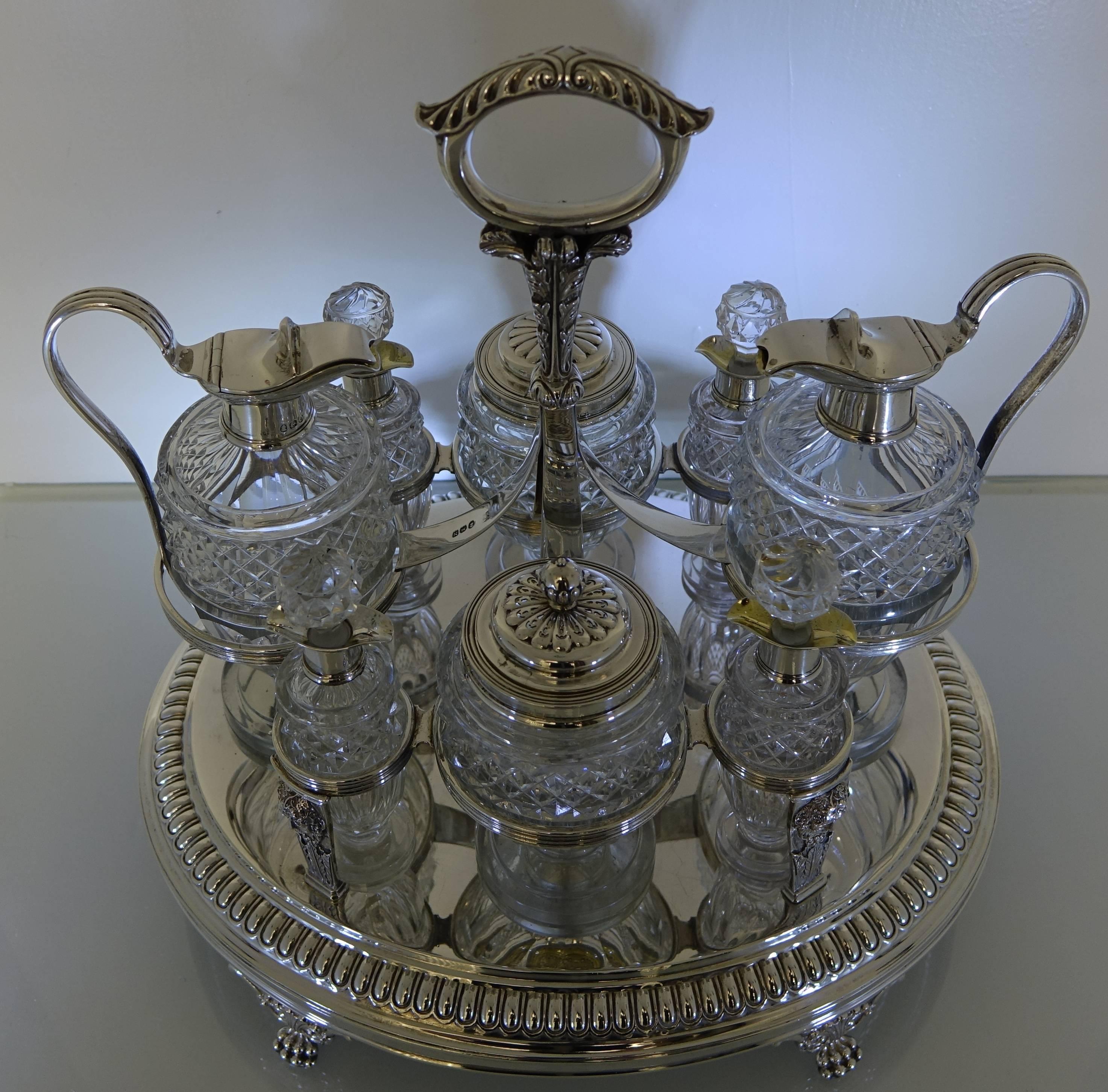 A very large and important looking silver eight bottle oval Georgian cruet. The cruet is very grand in size with a tongue border, cherubs and reeded decoration. The cruet has decorative claw feet and acanthus leaf handle. The glass bottles are hand
