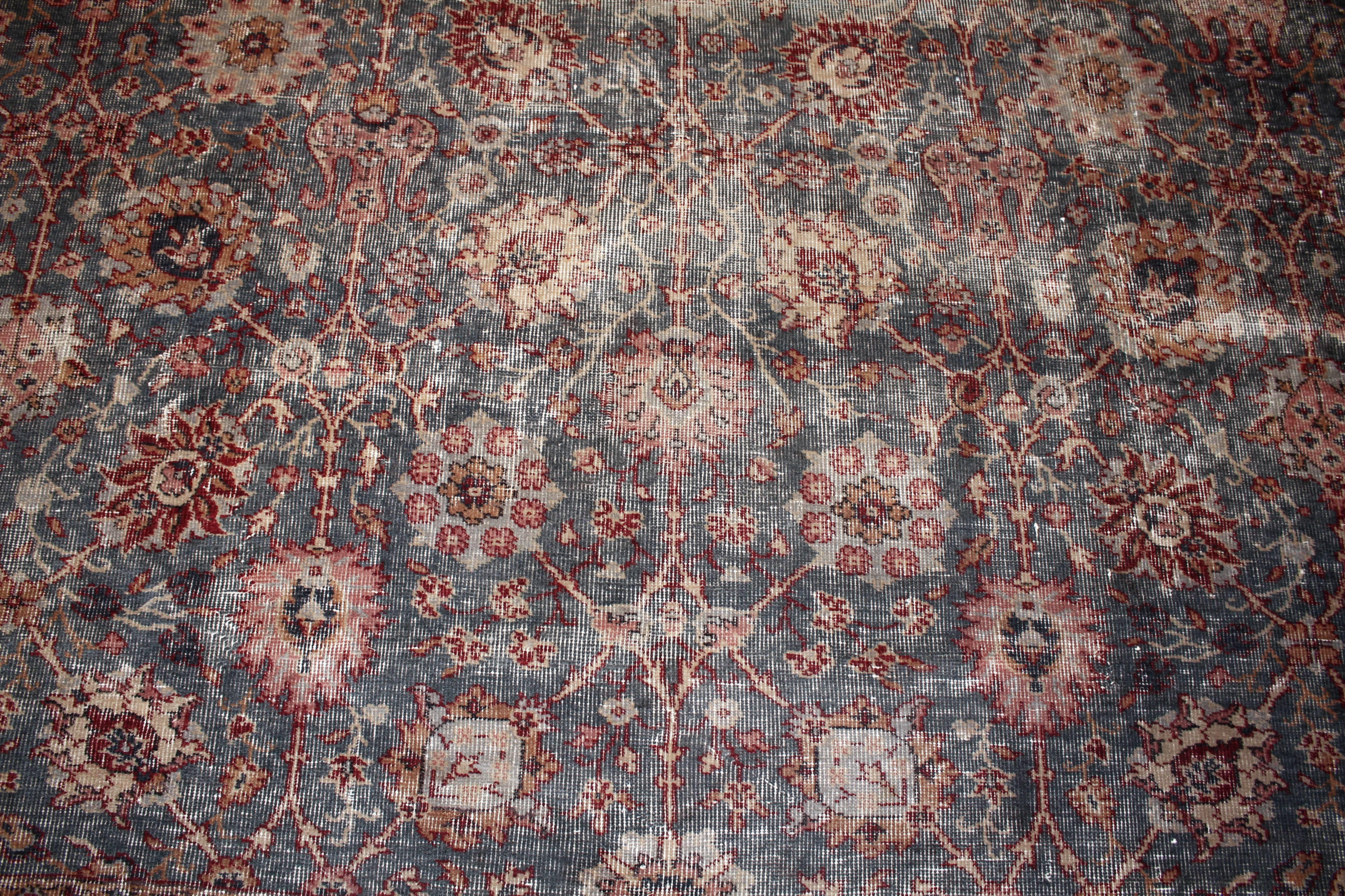 A distressed red and blue 1930s antique Sparta rug with repeating palmettes atop a lovely grey field. Measures: 10 x 14.