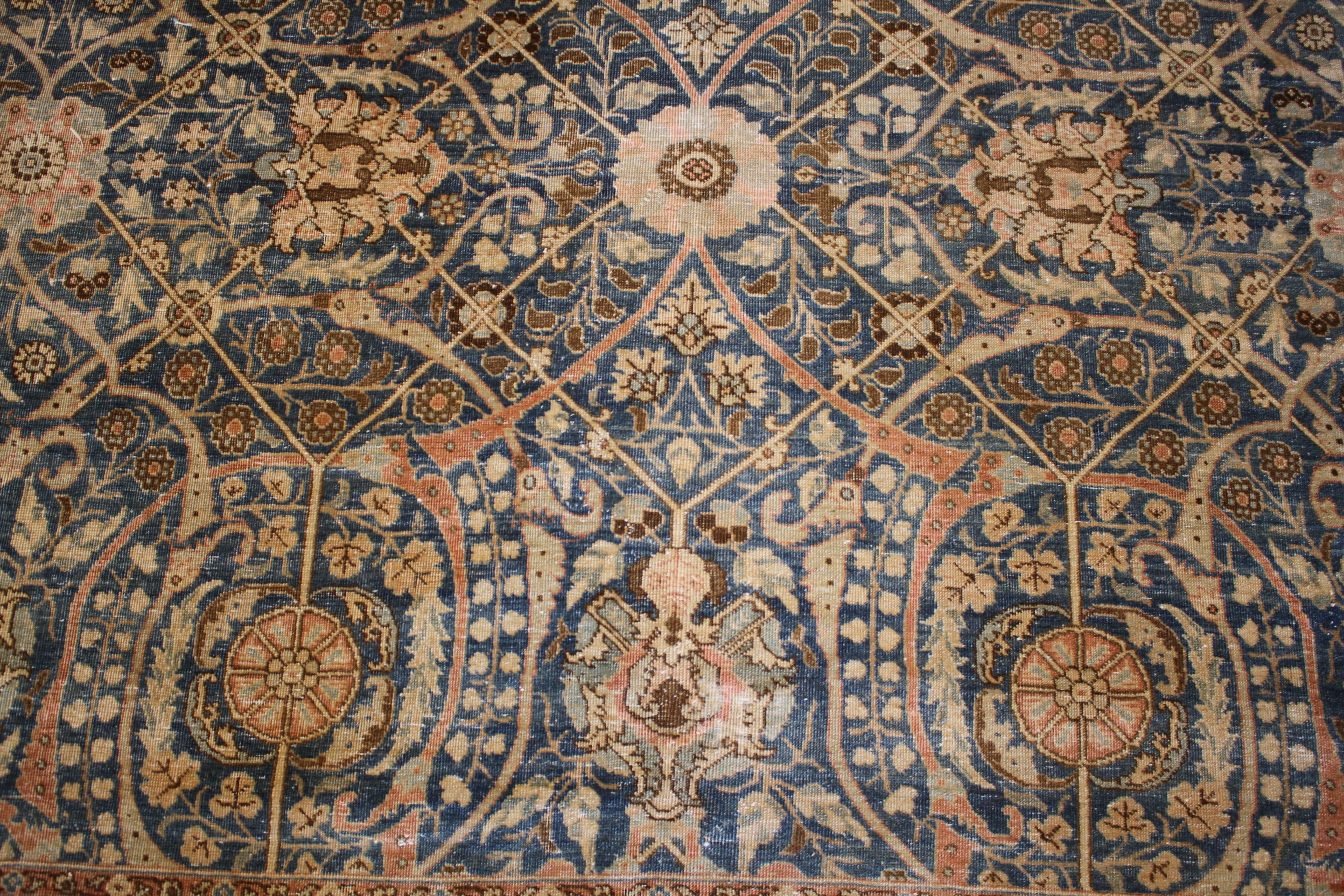 A blue and salmon antique Persian rug with an all-over Tabriz design. Measures: 110
