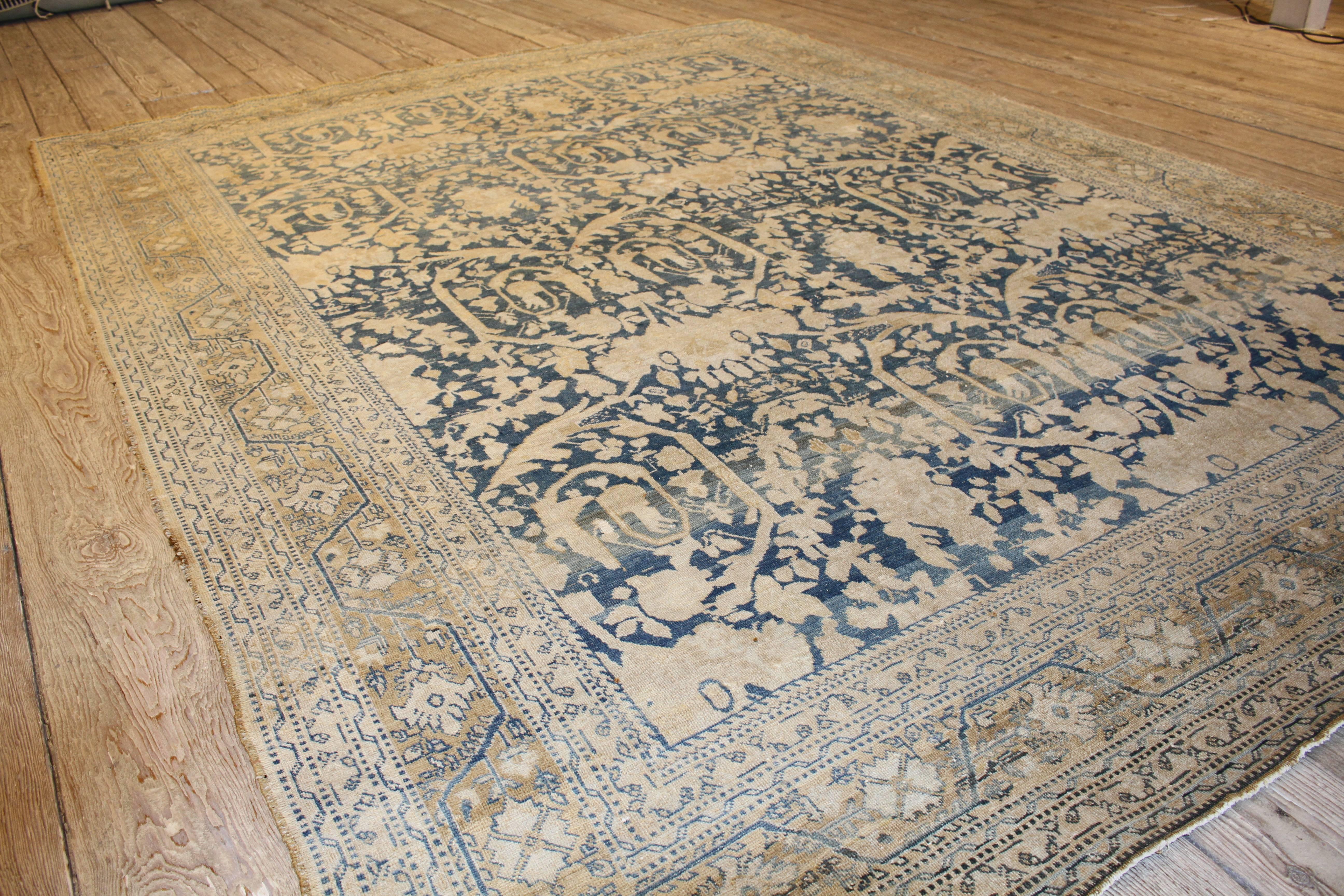 A blue and ivory antique Persian rug with an all-over Tabriz design. Measures: 96