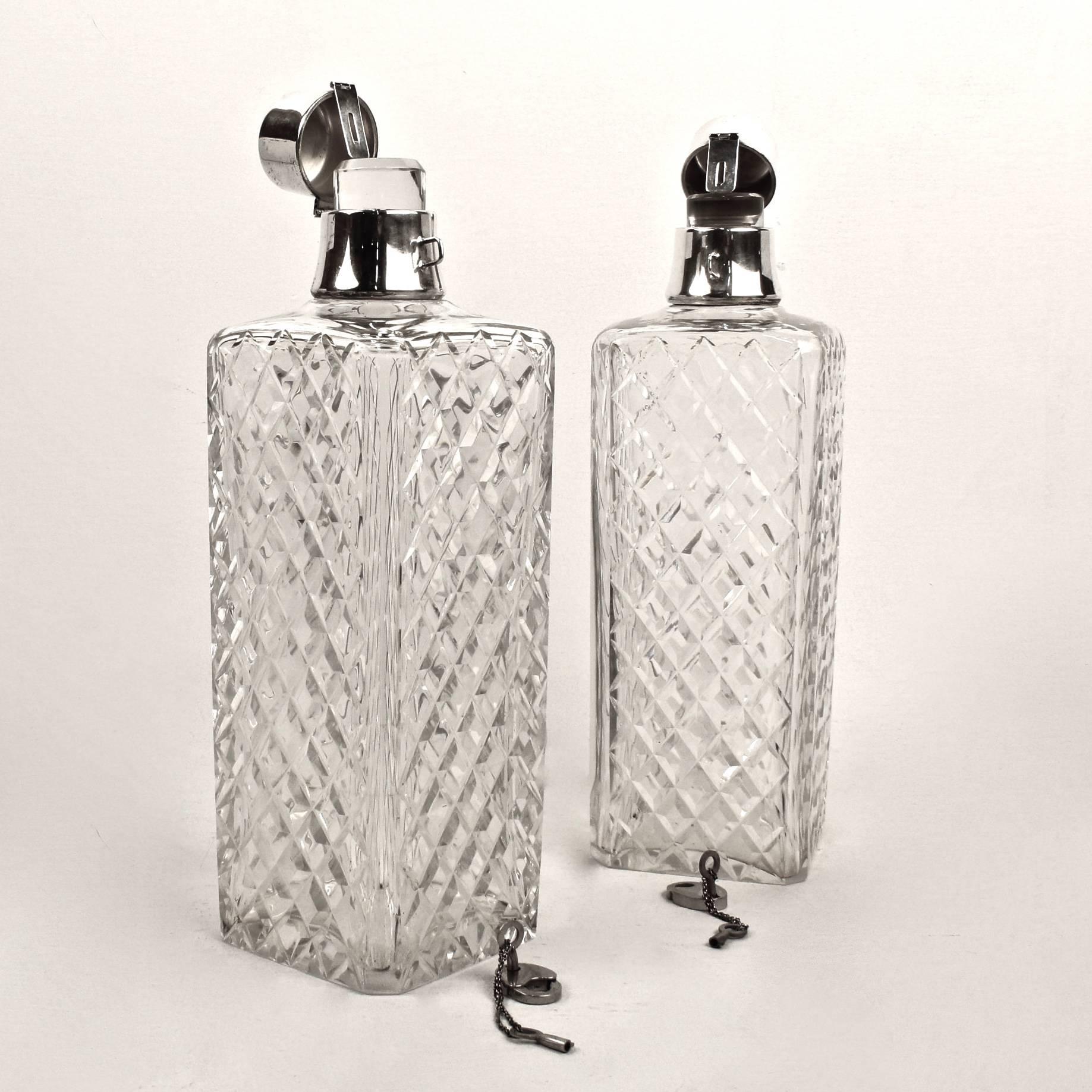 A terrific pair of hawkes cut crystal and sterling silver liquor decanters or cocktail bar bottles. 

Each square bodied bottle has a lockable sterling silver top that covers a glass stopper. The bodies are cut in a cross hatch pattern. 

Both
