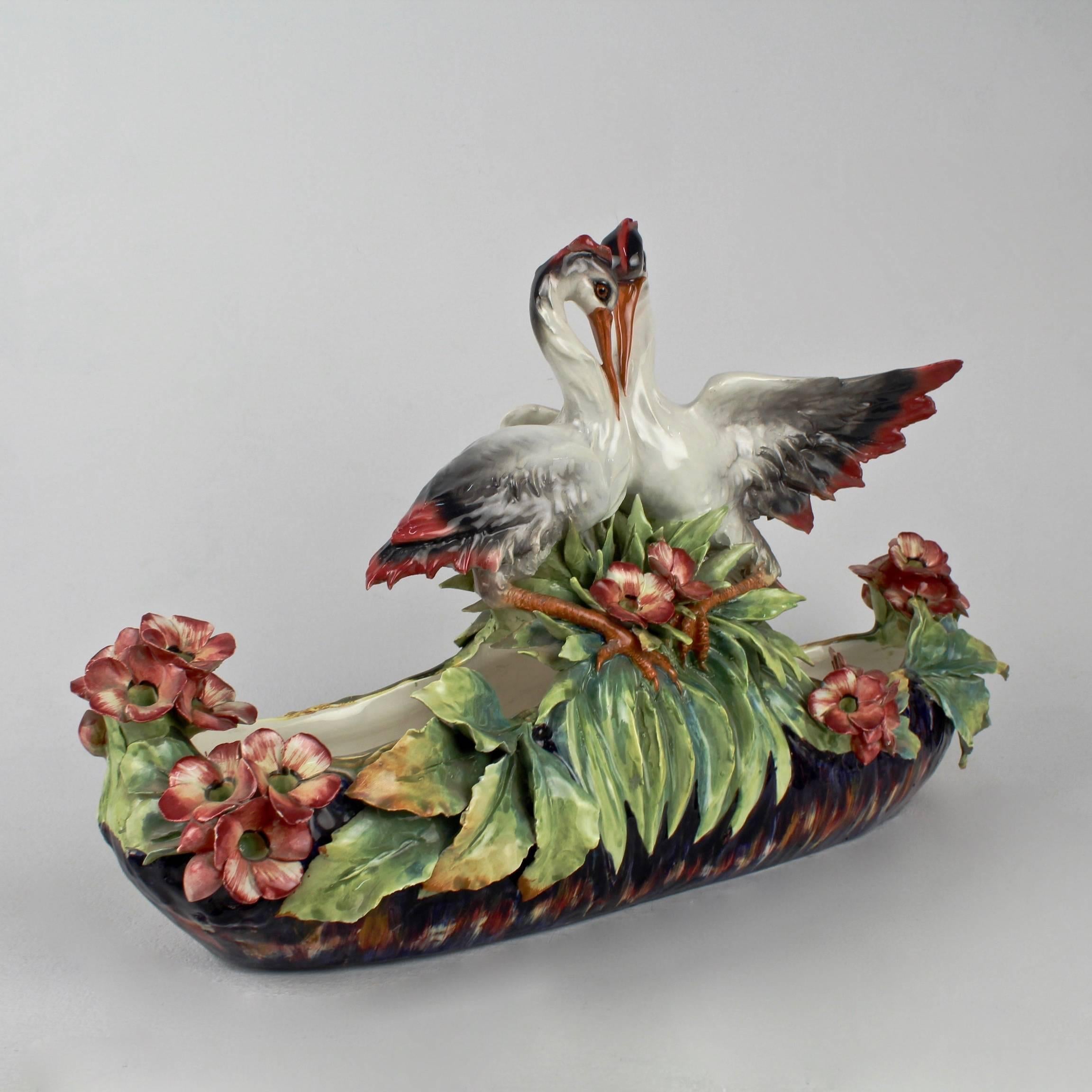 A very large figural Italian Majolica centerpiece by the Mollica Brothers factory.

Two herons rest atop a central handle. Tropical flowers and leafwork surround the rim. Vibrant colors and decoration throughout. 

Signed with an incised