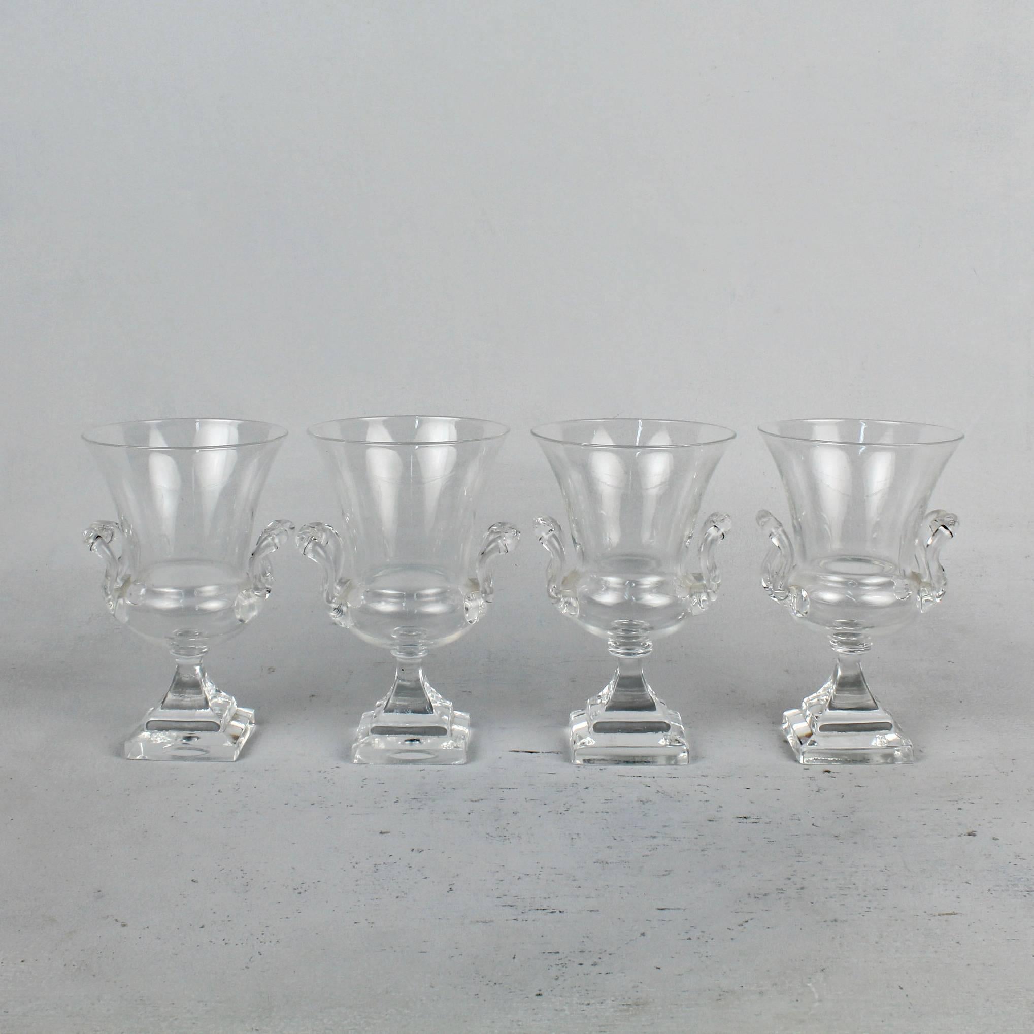 Four steuben glass campagna form urns.

Each urn has applied 'M' shaped handles and rests on a stepped base.

Bases each bear an etched factory mark.

Height each: circa 6 1/2 in.

Items purchased from David Sterner Antiques must delight