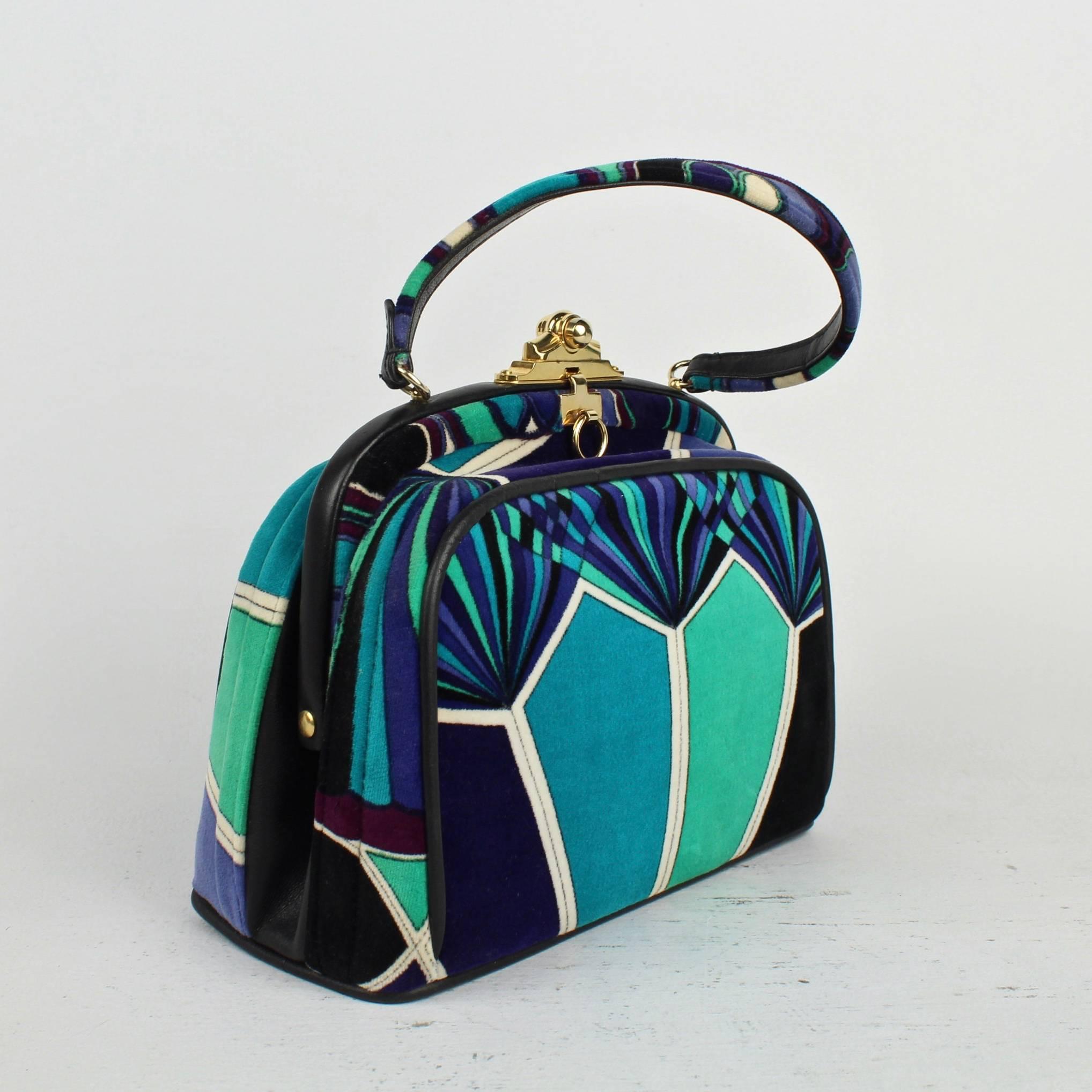 A Jana handbag with an exciting Emilo Pucci geometric velvet print in blues, green, black and white.

Quintessential 60s design.

The purse has leather trim and piping and a brass clasp.

Label reads: Emilio Pucci Bags - by Jana - Made in