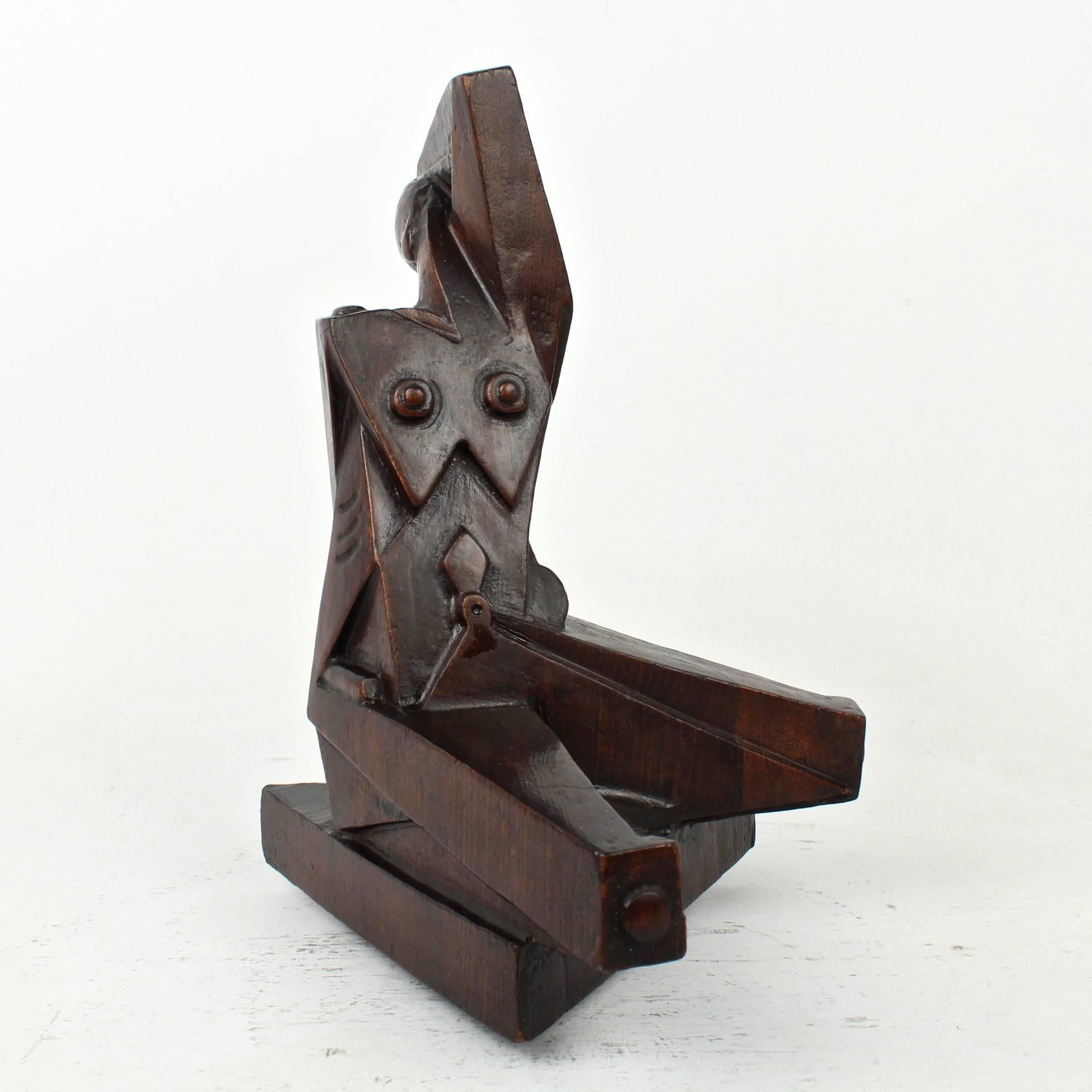 A carved wooden cubist sculpture of a seated nude woman by Boris Blai (1893-1985). 

This carving likely dates to the 1920s-1930s (during Blai's time in Philadelphia).

Most likely constructed of sections of laminated basswood stained with a