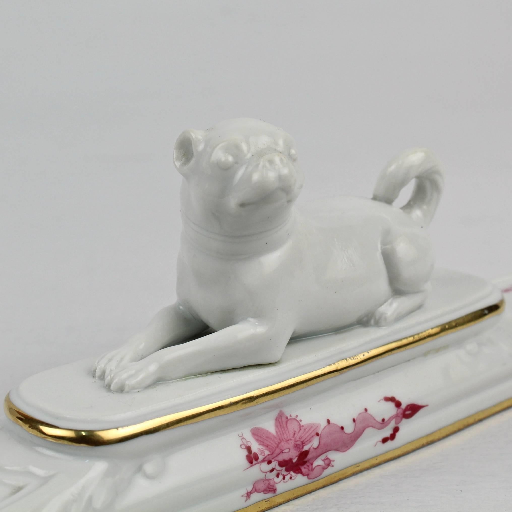 A Meissen porcelain paperweight with a full figural pug dog finial.

Decorated in the pink variant of the 