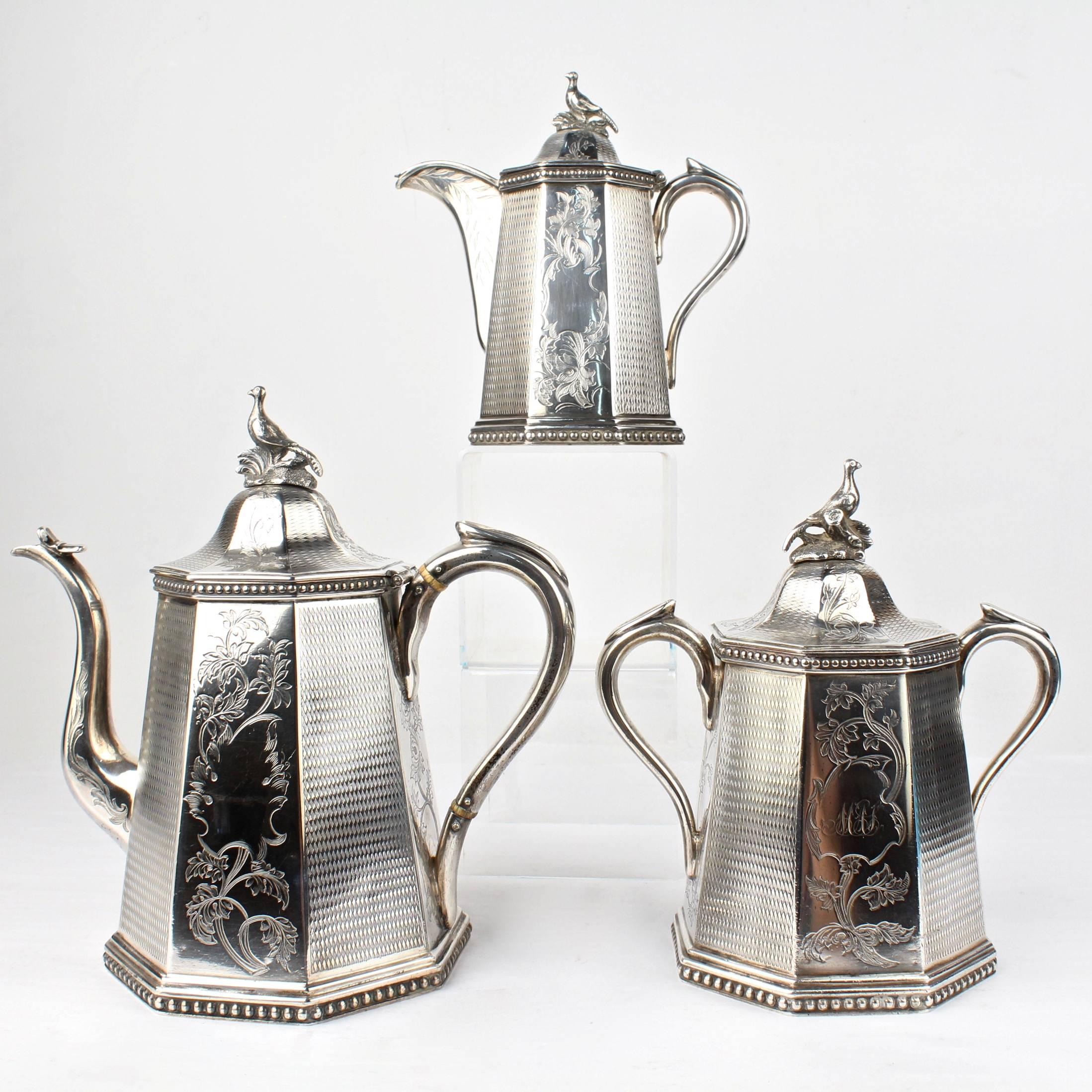 A heavy, three-piece, 19th century American coin silver tea set by the renowned New York silversmiths, Wood & Hughes.

Finely engraved with vine and leafwork panels that alternate with panels of etched diamond fields. The central cartouches each
