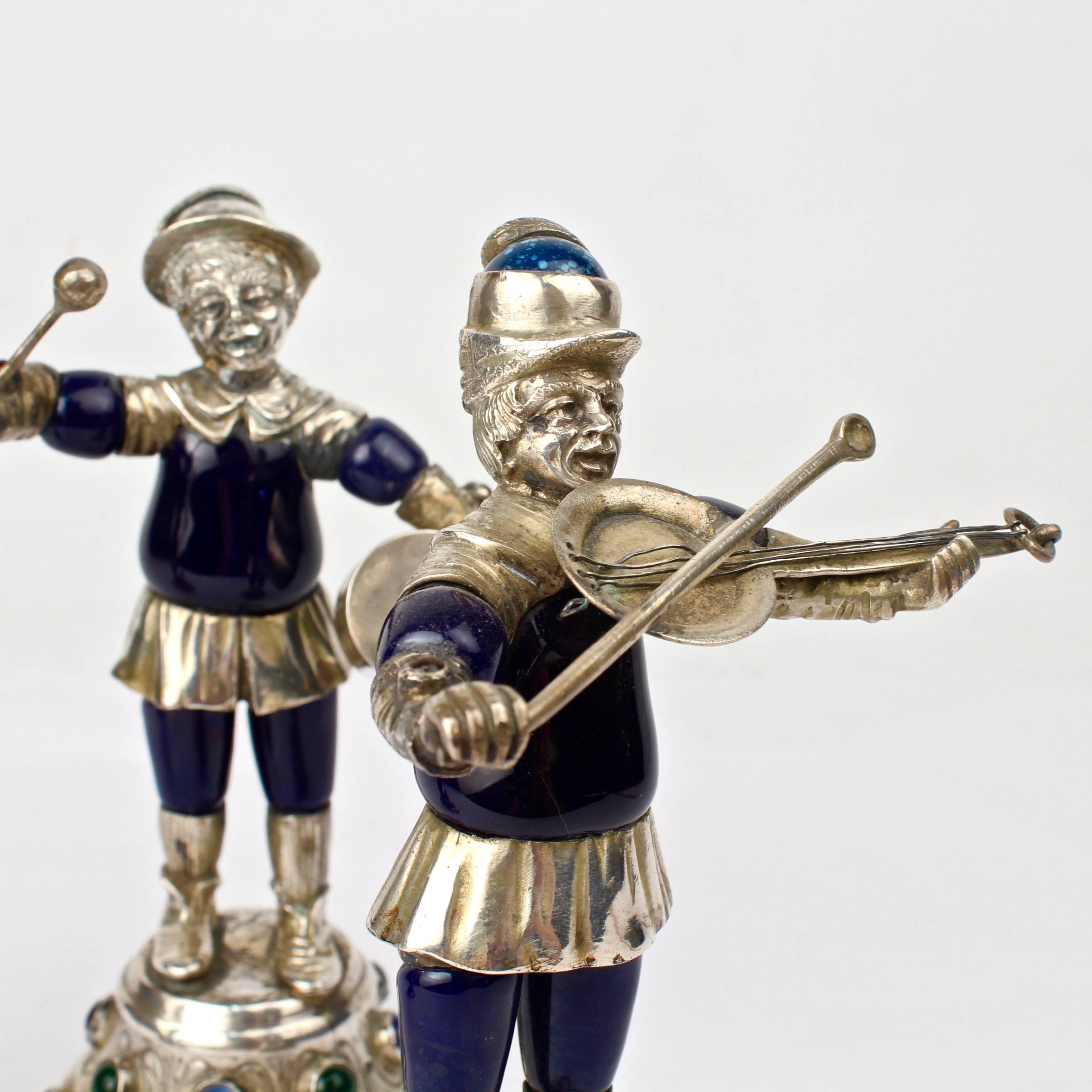 A group of three rare and terrifically whimsical German or Austrian Silver musician figures. Constructed of coin silver and enamel bodies with glass cabochon jewels to the bases.

This types of figures were coveted and widely collected in Europe