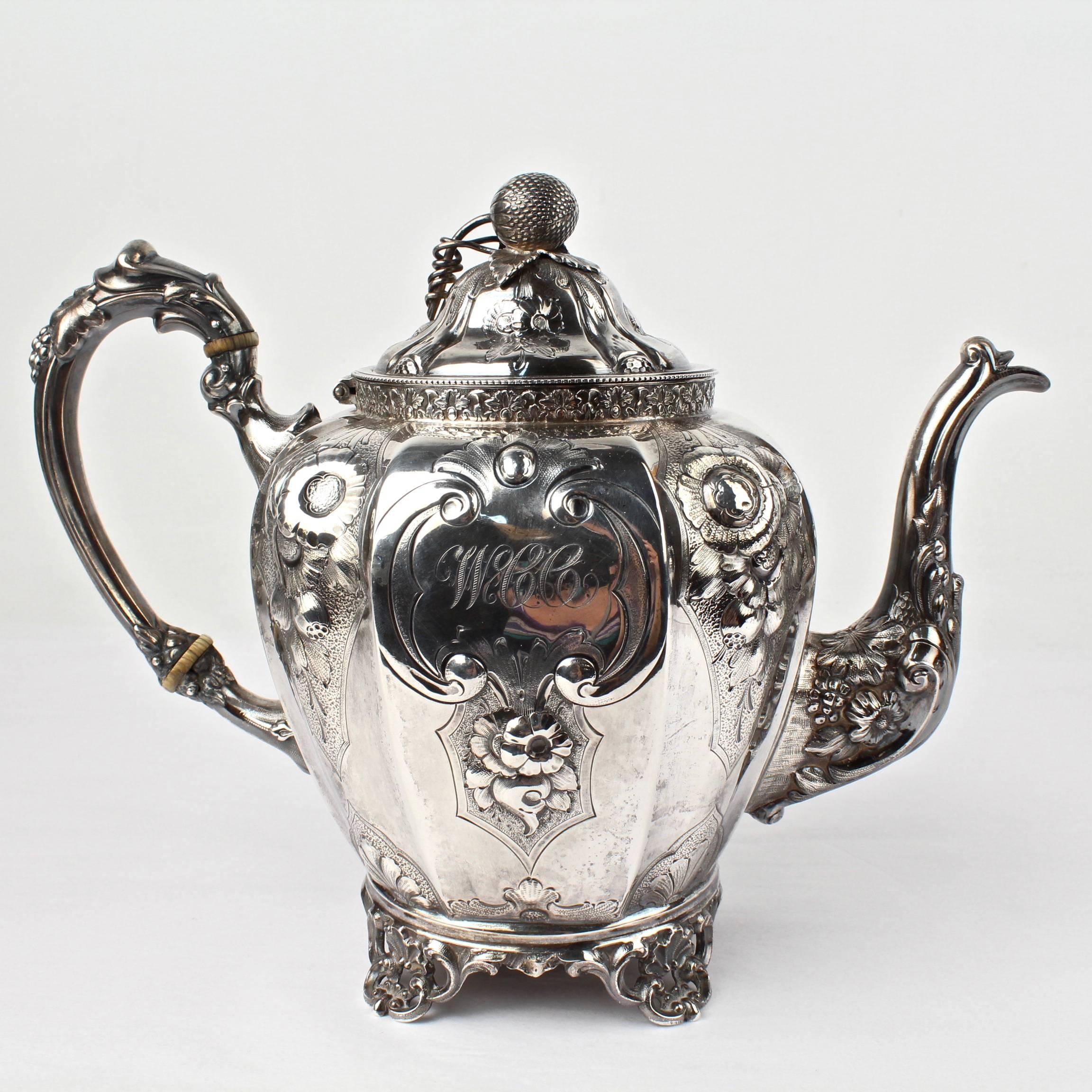 A large, four-piece, 19th century American coin silver tea set by the renowned New York silversmiths, Wood & Hughes. A stately and impressive set.

Finely worked with repousse decoration throughout. The central cartouches each bear an early