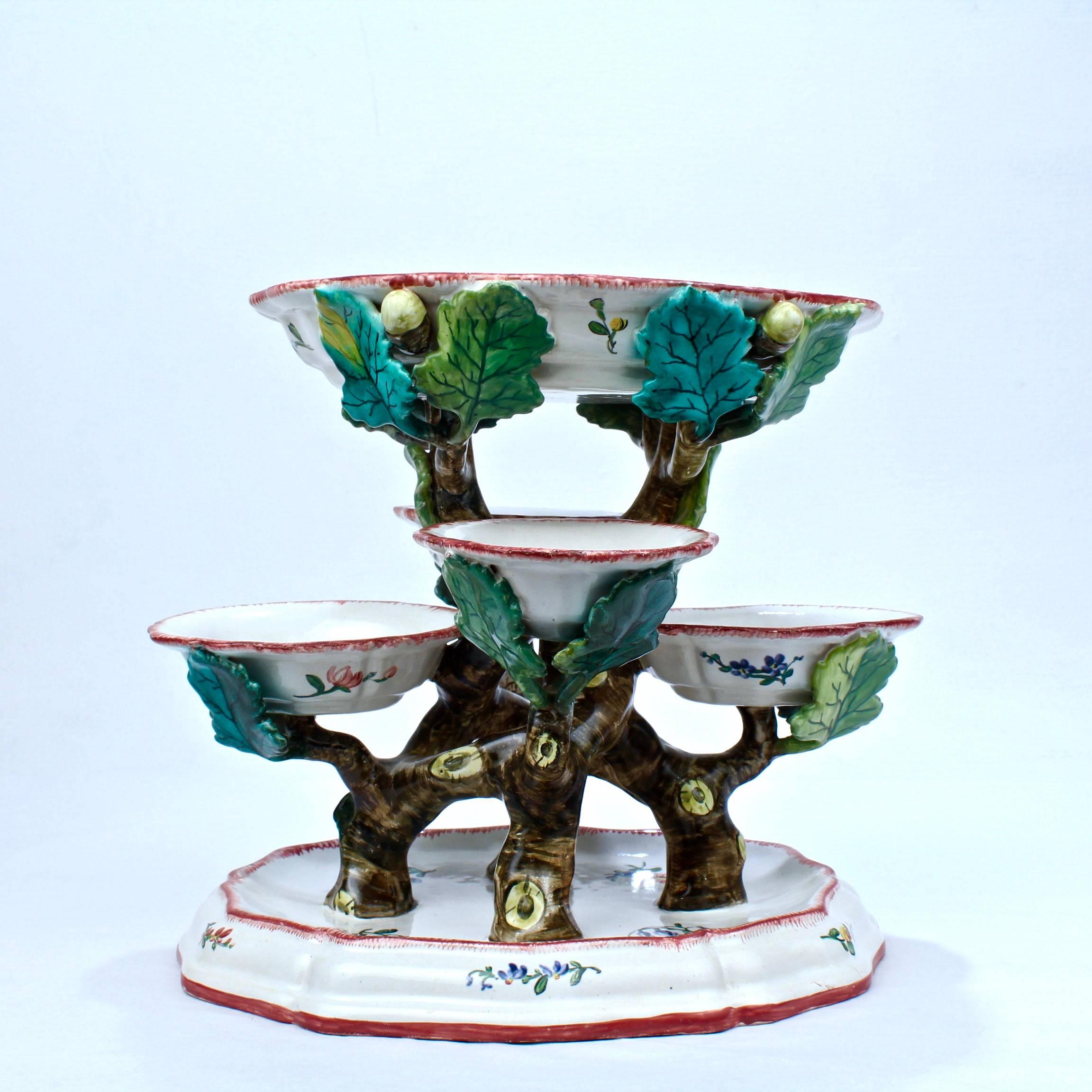 A fine, antique faience figural sweetmeat stand marked for Veuve Perrin.

Five sweetmeat cups rest on figural Intertwined branches and are supported by a conforming inverted foot.

The underside is marked VP.

Height, circa 8 3/4 in.

Items