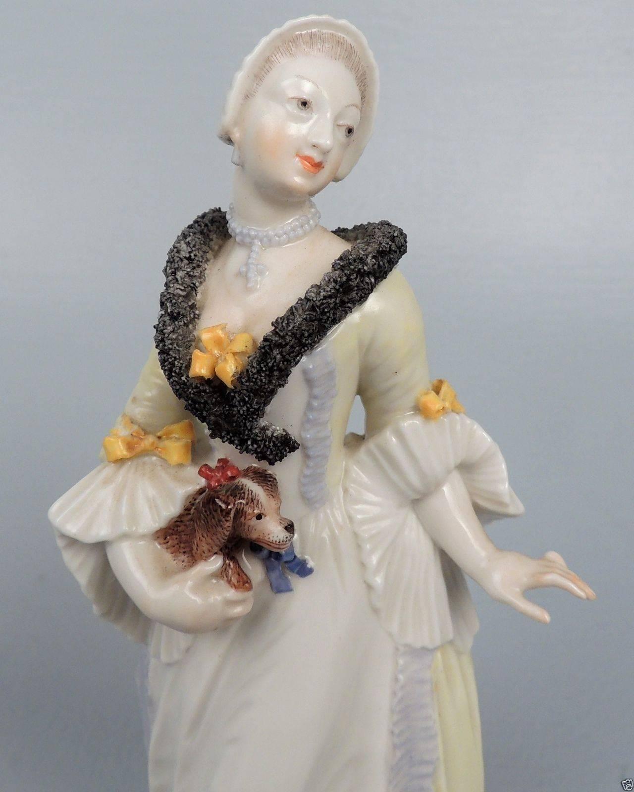 A fine and Nymphenburg porcelain figurine of a lady and her King Charles Spaniel.  

Quite possibly a figure from the Franz Anton Bustelli Commedia Dell 'Arte series.

Marked in the plinth and on the base with an impressed factory mark and