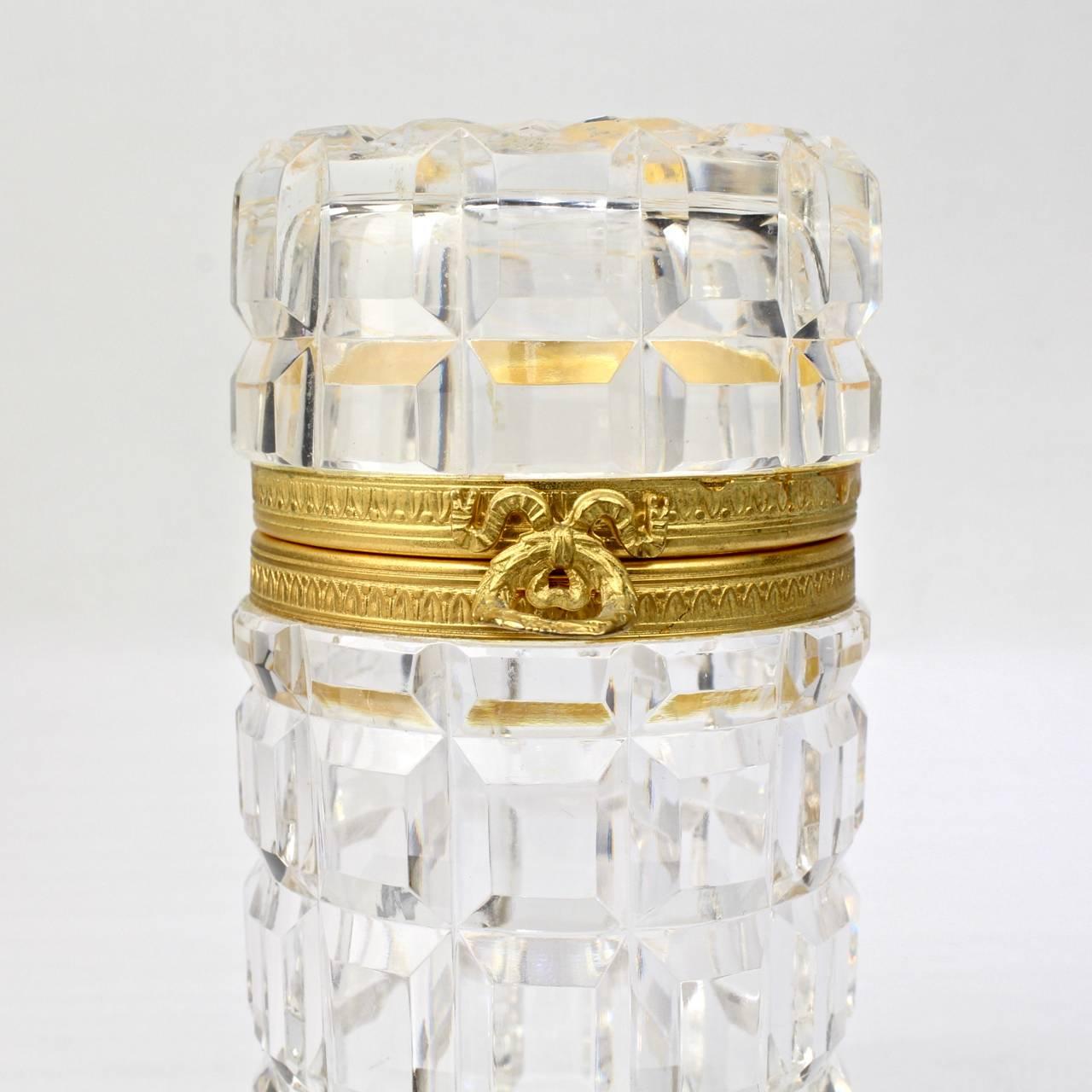 A fine, vintage French cut glass dresser or vanity box. 

Of cylindrical form with gilt bronze hinge and mounts. With a field of deep rectangular cuts around the entire body and top. 

Height: ca. 5 1/4

Items purchased from David Sterner