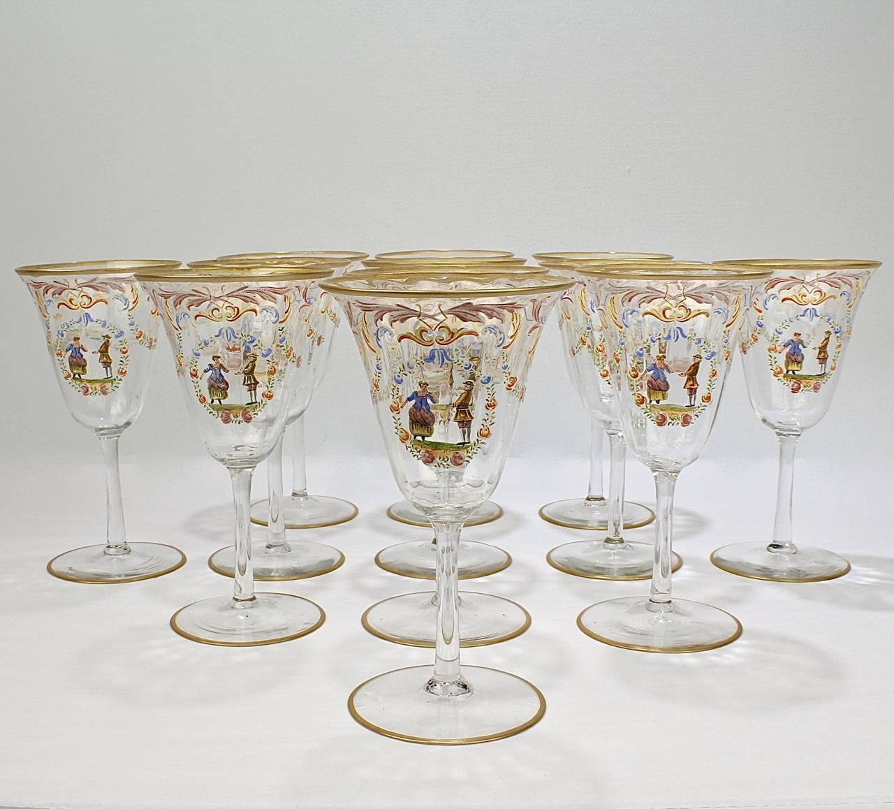 A full set of 12 enameled Italian or Venetian glass water goblets or wine glasses. 

With polychrome Florentine enamel decoration, a central cartouche bearing a peasant couple surrounded by a wreath with rose, and gilded feet and