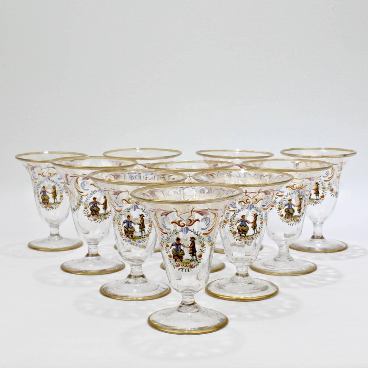 A set of ten enamelled Italian or Venetian glass short stemmed cordial (or possibly Syllabub) glasses. 

With polychrome Florentine enamel decoration, a central cartouche bearing a peasant couple surrounded by a wreath with rose, and gilded feet