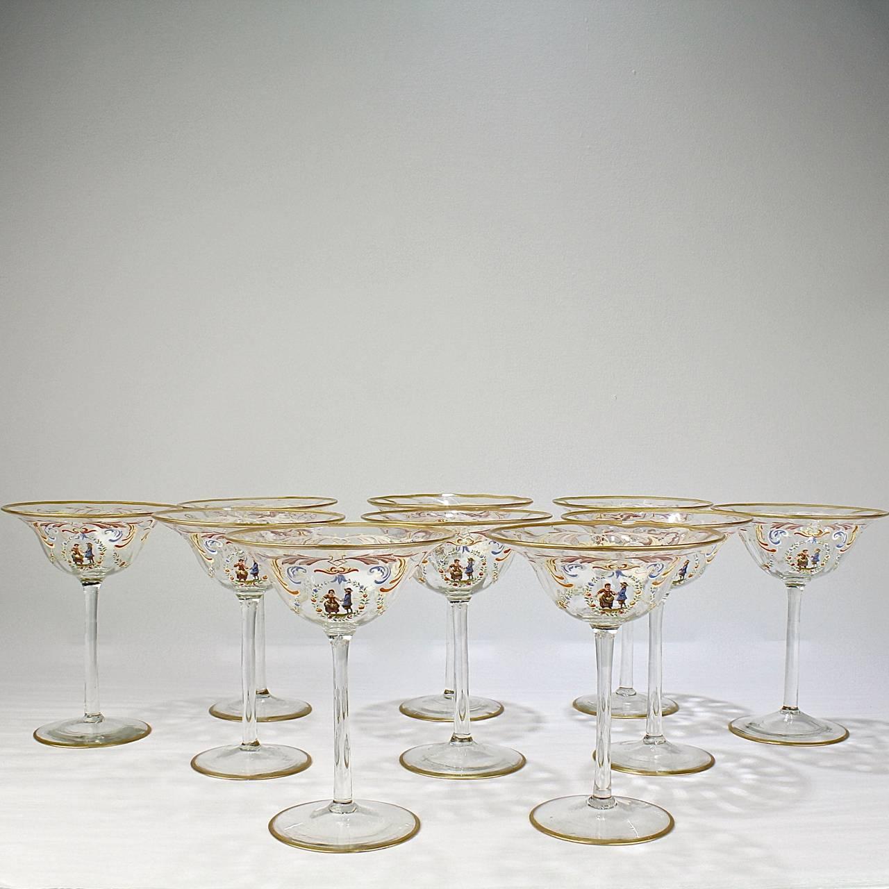 A set of ten enamelled Italian or Venetian glass champagne glasses. 

With polychrome Florentine enamel decoration, a central cartouche bearing a peasant couple surrounded by a wreath with rose, and gilded feet and rims.

Attributed to Salviati.