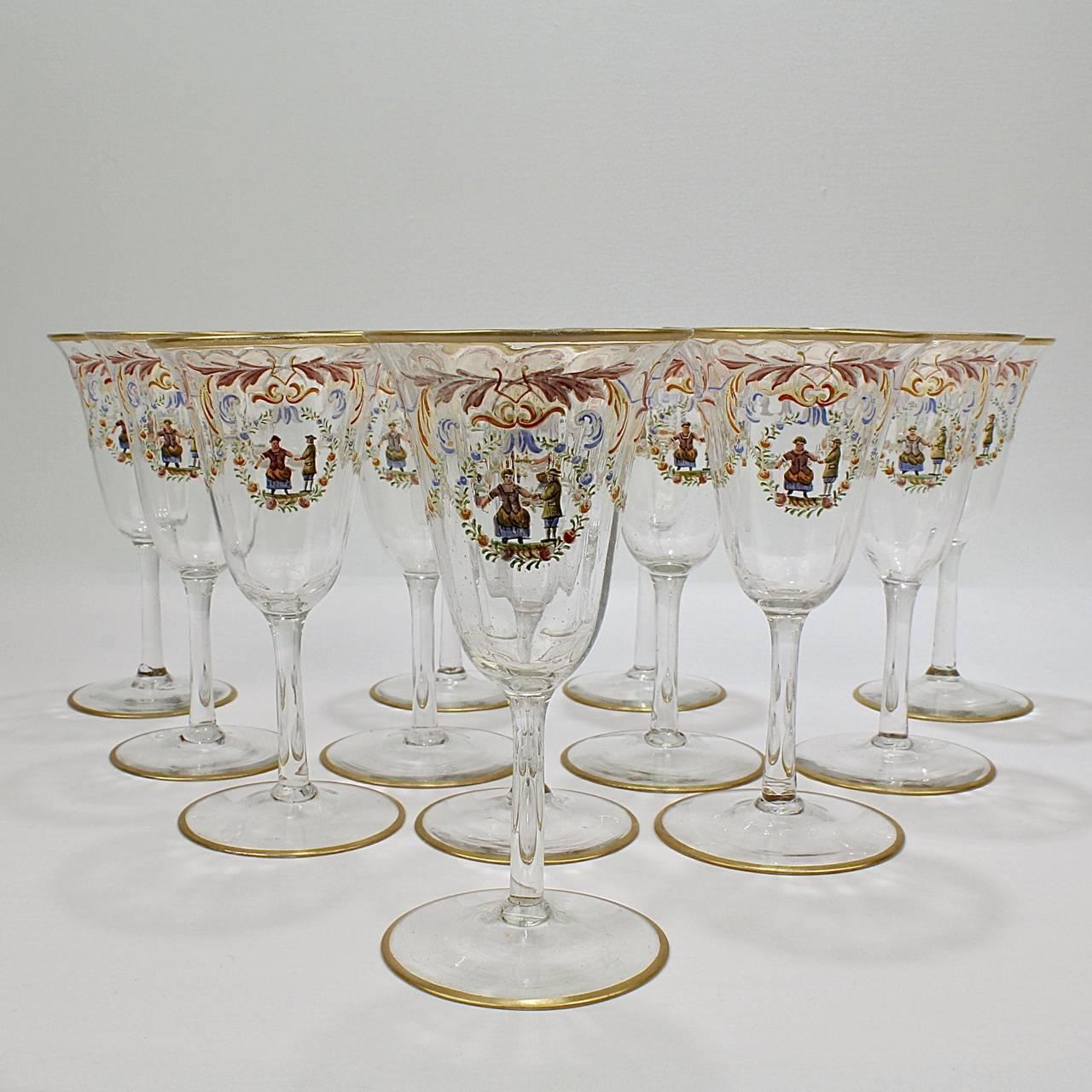 A full set of 12 enameled Italian or Venetian glass white wine glasses. 

With polychrome Florentine enamel decoration, a central cartouche bearing a peasant couple surrounded by a wreath with rose, and gilded feet and rims.

Attributed to