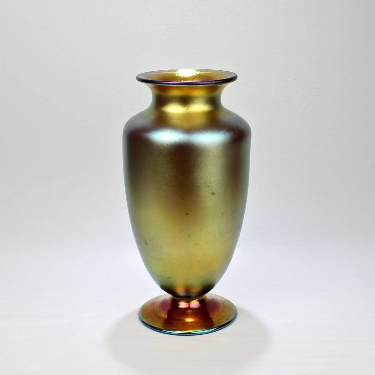 A large unsigned gold aurene vase. 

Attributed to Steuben. Likely model no. 3285.

With a blue to gold iridescent finish. 

Base has a rough pontil mark.

Height: ca. 13 1/4 in.

Items purchased from David Sterner Antiques must delight you.