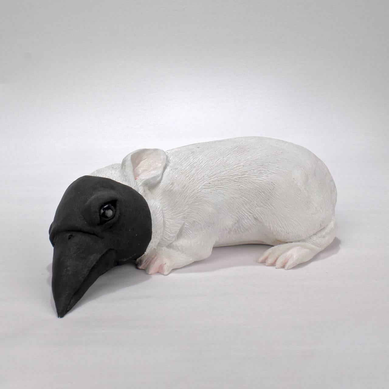Baby bunny with crow's mask. 

A white painted and black graphite decorated hydrocal plaster sculpture by Darla Jackson.

Signed and dated to base: D Jackson 2011.

Length: circa 7 1/8 in.

Also available in bronze on commission basis at