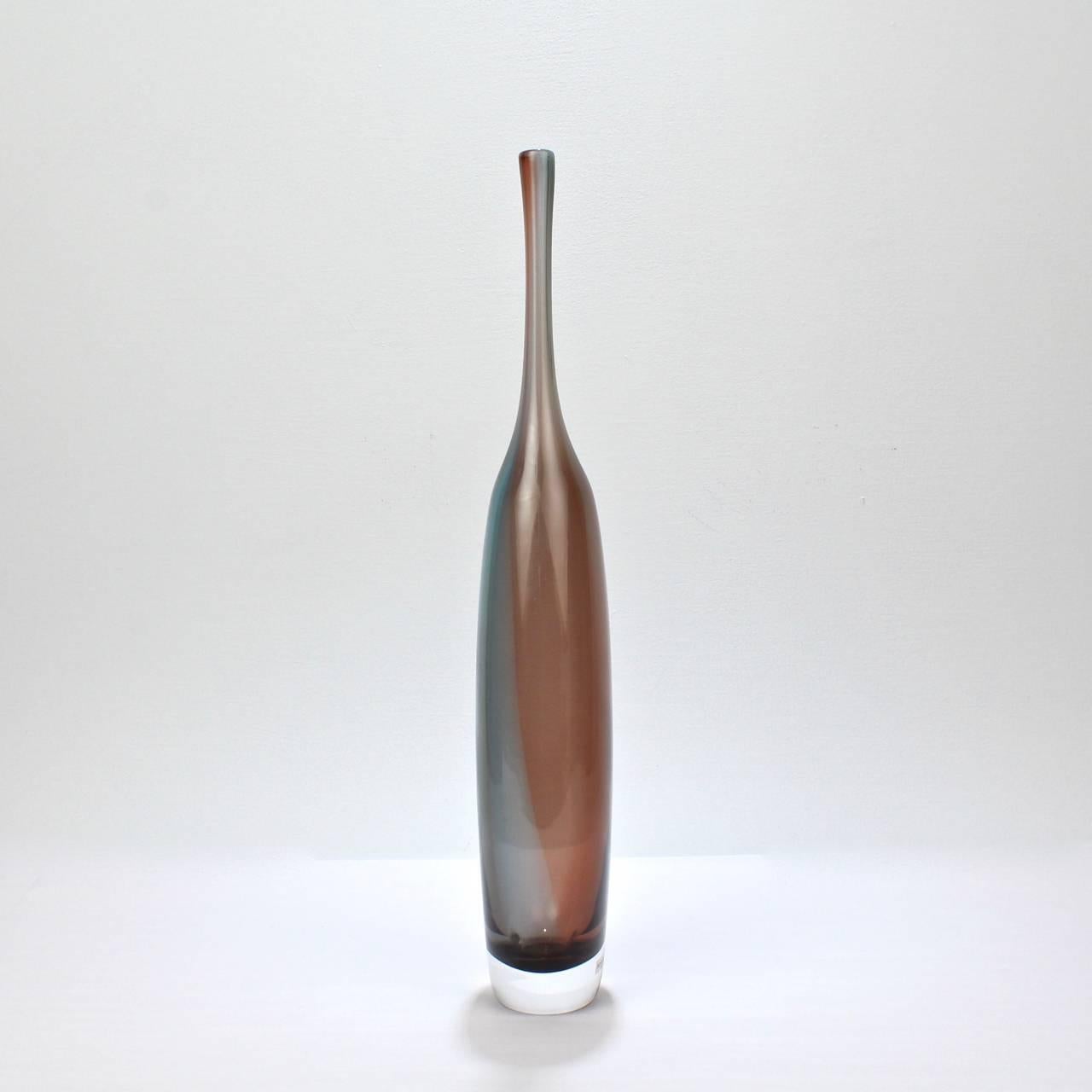 A fine, tall Tobago series bottle form vase. 

Designed by Kjell Engmann for Kosta Boda.

Consisting of red and blue colors that can read purple to gray depending on light. 

Bears a factory sticker to side. 

Base unmarked.

Items