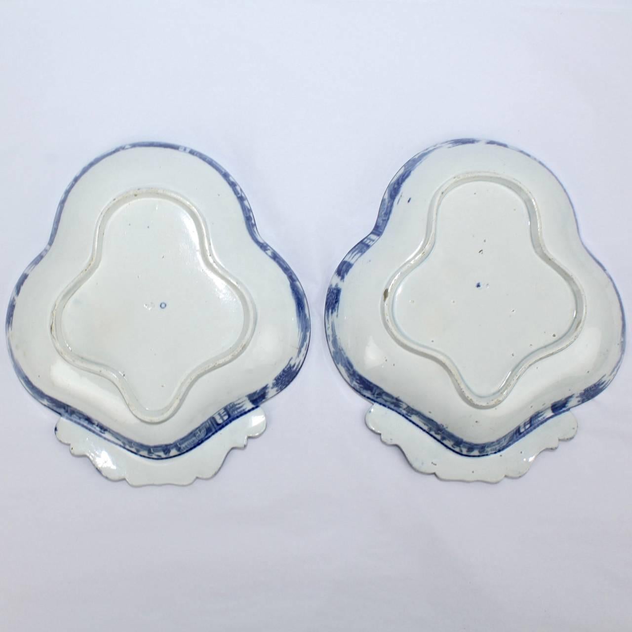 A rare pair of early English soft-paste porcelain shrimp dishes.

With finely detailed blue transferware decoration depicting a Chinoiserie scene of Chinese palaces, balcony, horses and figures.

Likely manufactured by Clews or Spode.

Marked