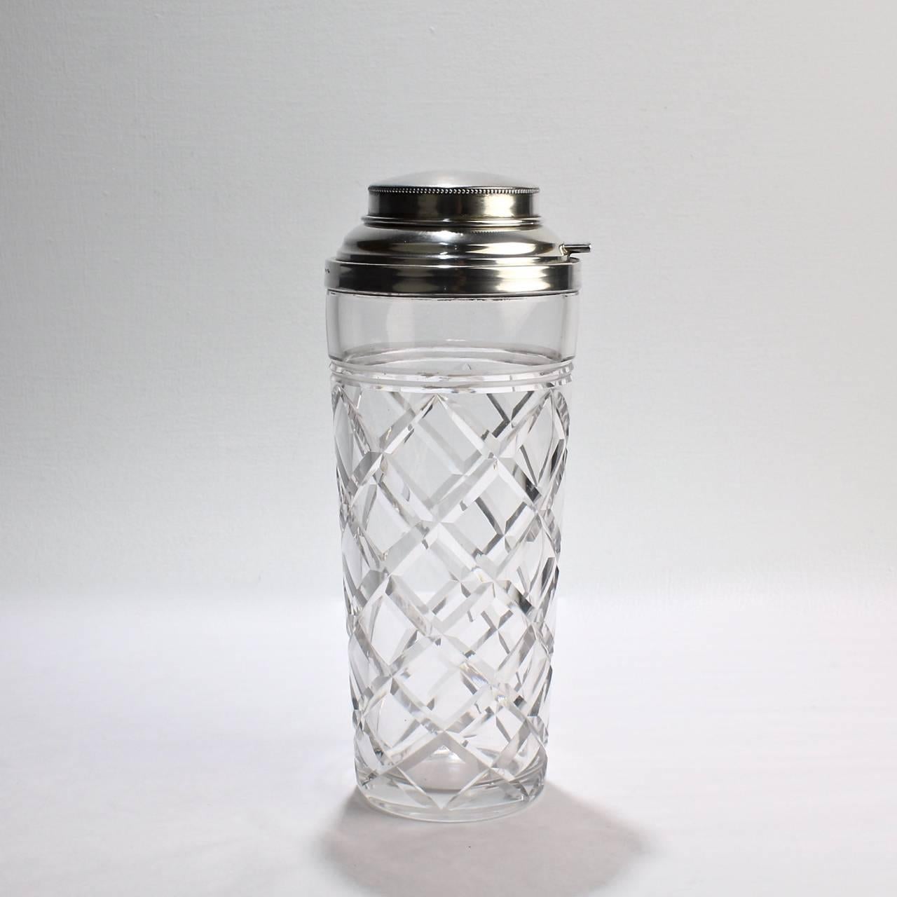A good American cut-glass and sterling silver Art Deco cocktail shaker.

With an open side spout for pouring (to be covered with the thumb when shaking).

Lid and mount both marked for Webster and Co. and sterling silver. 

Height: ca. 9 1/2