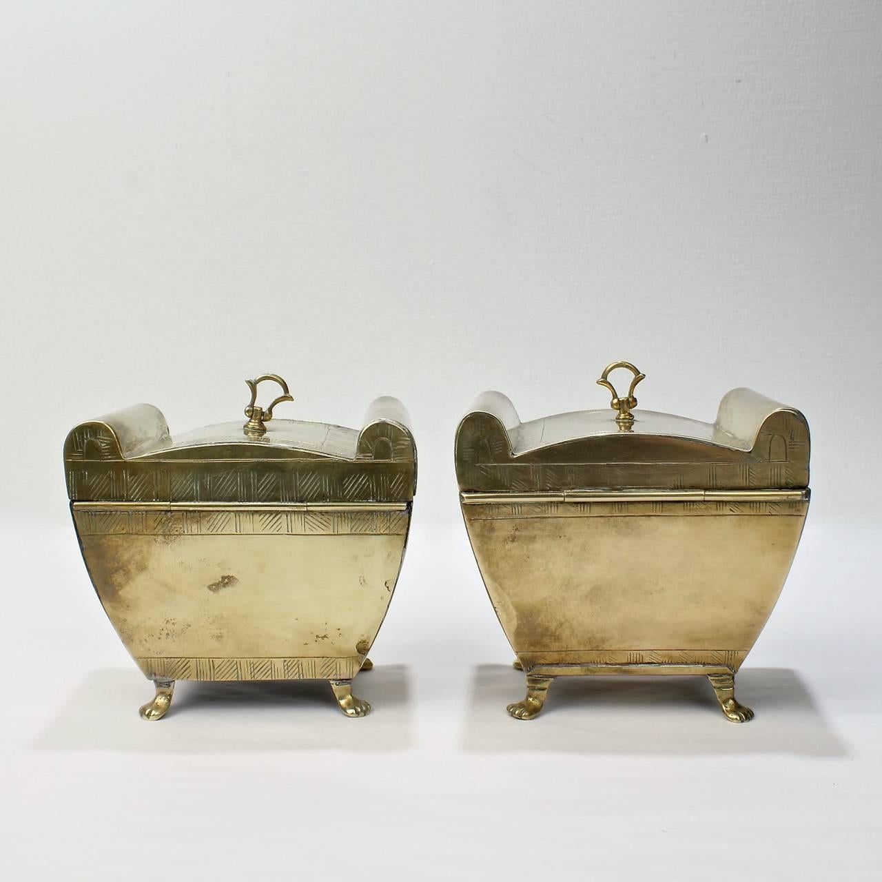 A matched pair of Anglo-Indian brass tea caddies.

Of relatively primitive construction with sarcophagus form bodies on paw feet. Each with a hinged finial to the lid.

Width: ca. 4 1/2 in.

Items purchased from David Sterner Antiques must