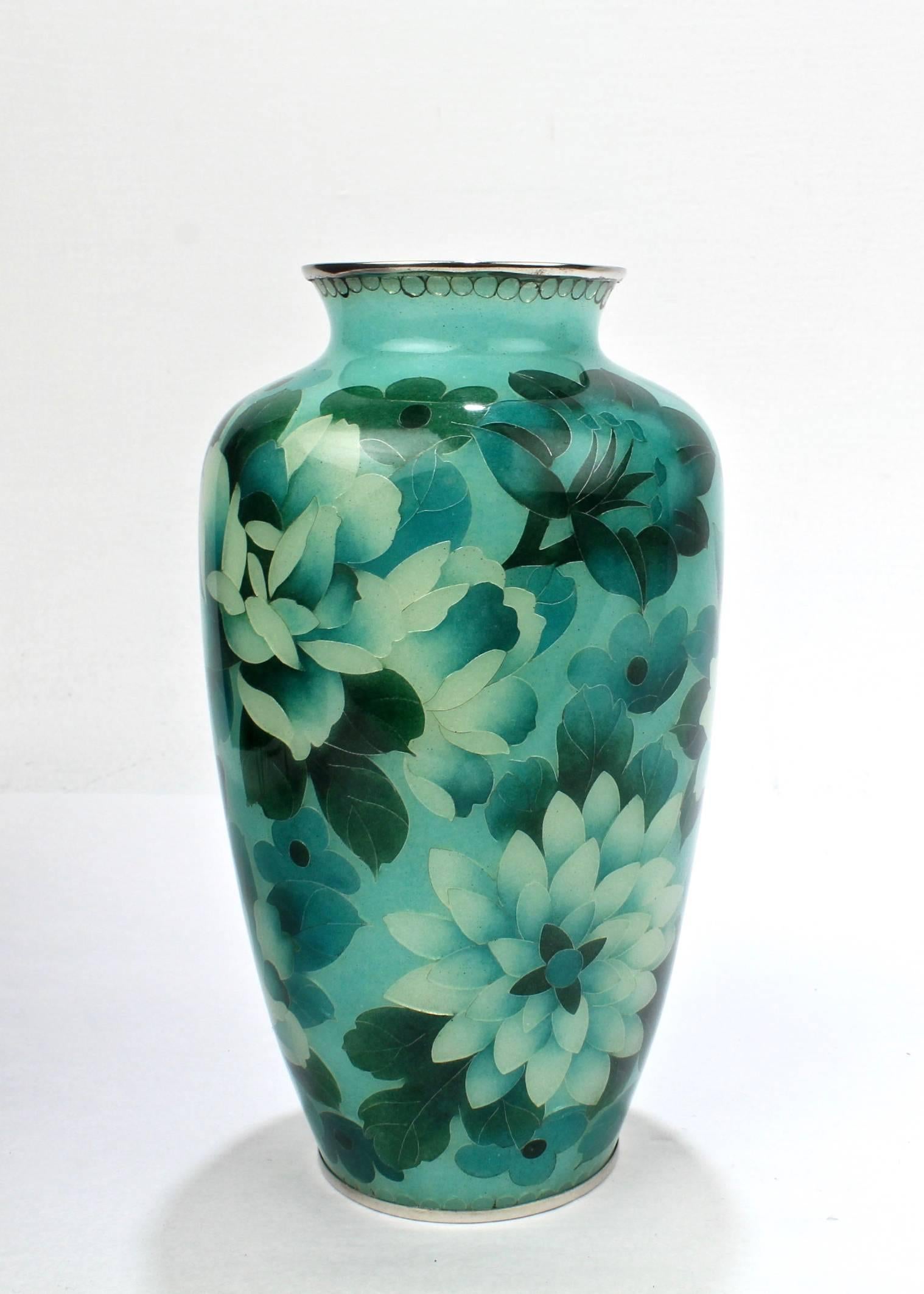 A finely crafted Japanese Plique-à-jour enamel baluster form vase.

With varying green palette enamels depicting stylized flowers with a silver colored wire, rim, and foot.

The translucent enamels in the vase catch and redirect the surrounding