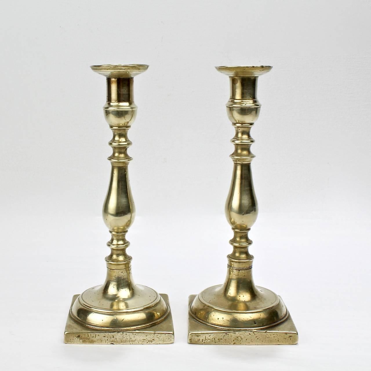 A Fine and very solid pair of early 19th century brass Continental candlesticks.

Likely Northern European (or possibly Russian) in origin.

With candle cups on turned supports and square bases. Each is quite heavy.

Measures: Height: ca. 8