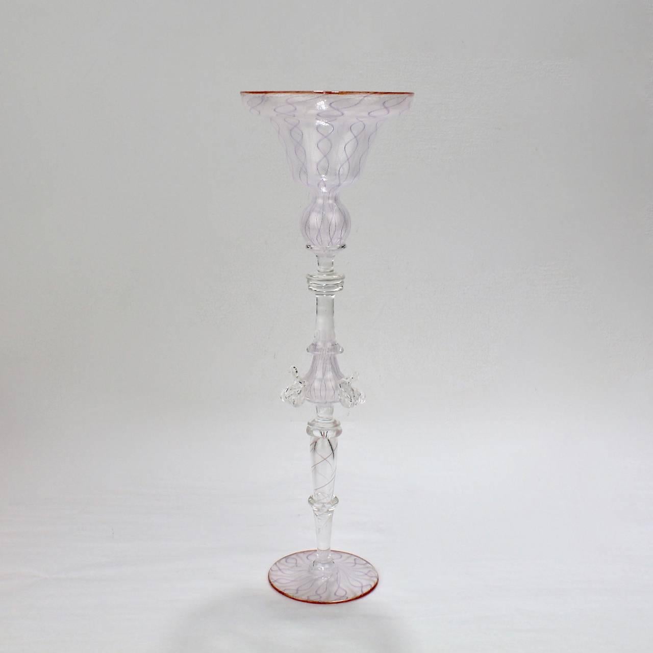 A tall, white zanfirico glass goblet by Charles Paul Savoie.

Savoie's work is inspired by the elaborate Venetian glass of the 17th century. 

His work is widely held in public and private collection, including in the Renwick Gallery of American