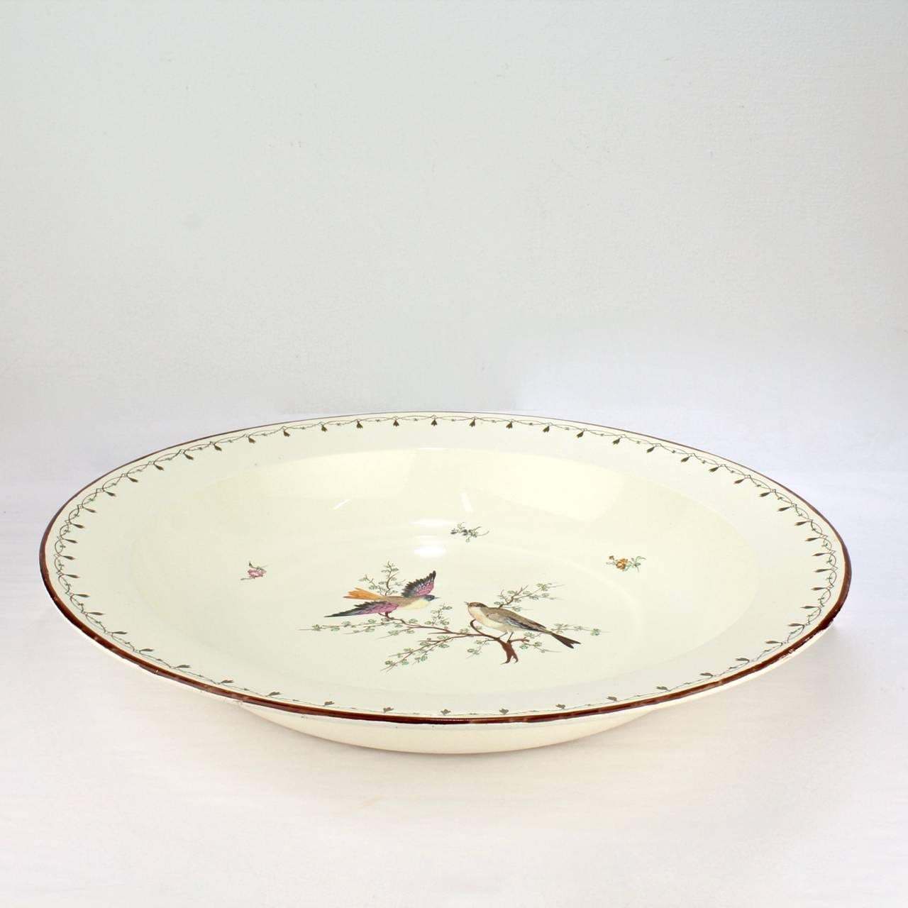 An impressively large, early 19th century Wedgwood creamware bowl. 

Ideal to hold the centre of a well-set table or as wall or mantel piece.

With hand-painted birds on branches, floral sprays, and a loop and arrow border decoration.

This