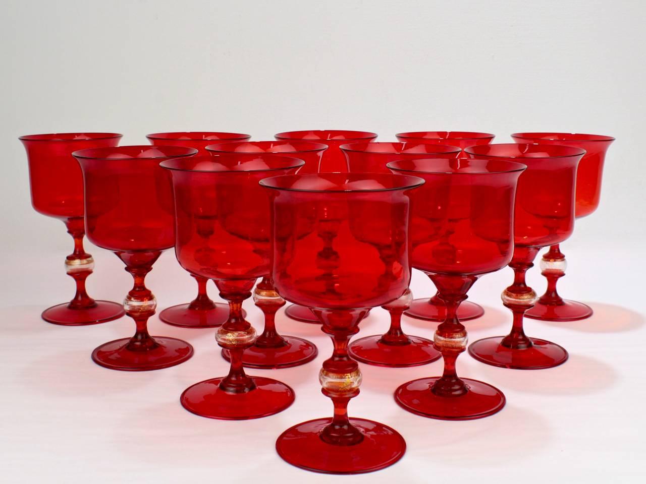 A complete set of 12 red Venetian glass wine goblets.

The wine glasses have cups supported by pedestals the central spheres with gold fleck decoration and disk feet with a folded edge.

Height: ca. 6 1/2 in.

Items purchased from David