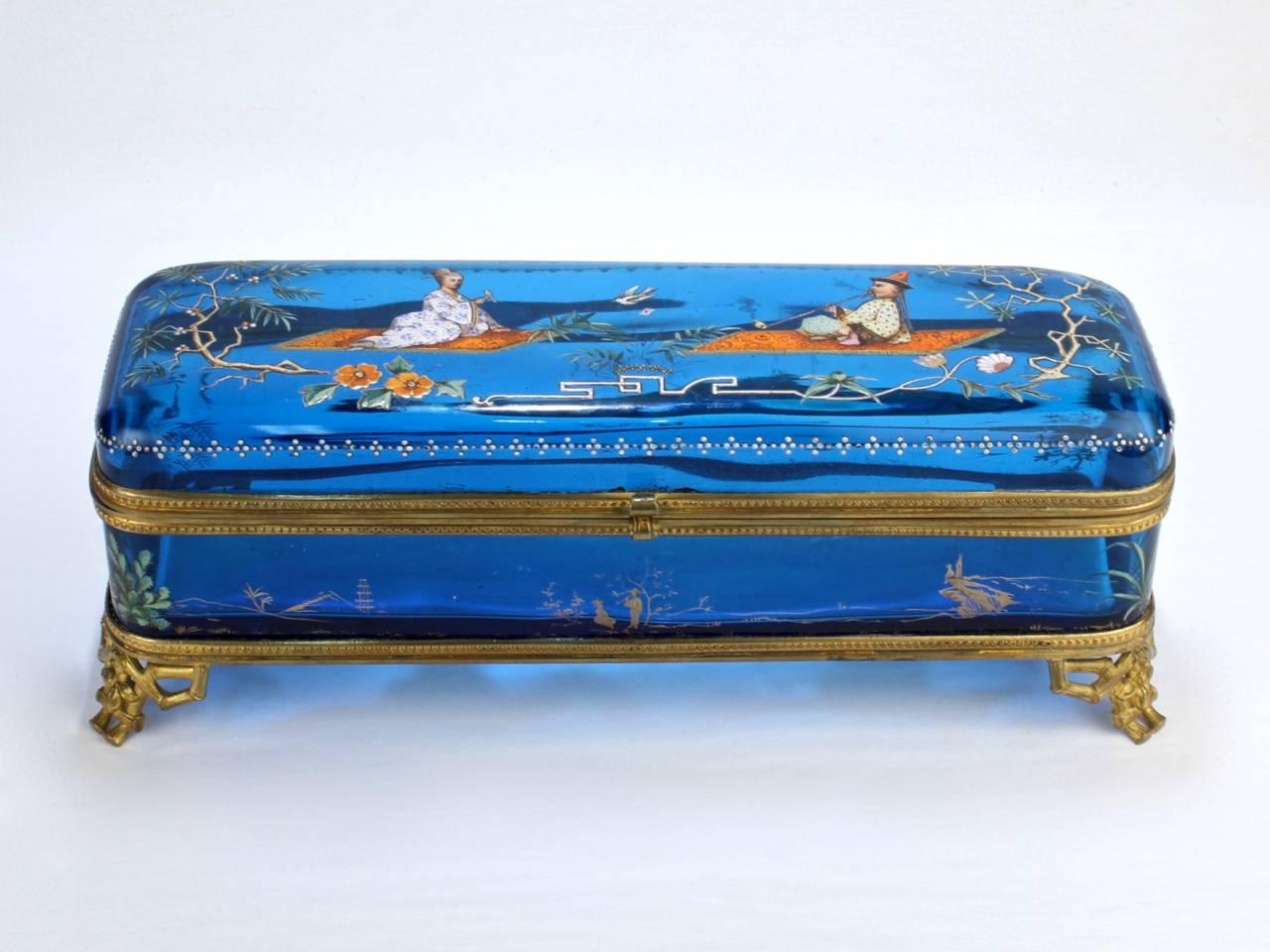 A large and very fine 19th century enameled glass casket or glove box. 

Typical of the enamel treatments by Ludwig Moser and reminiscent of Baccarat's Japonisme works.

Likely Bohemian, the blue glass box is mounted in a gilt bronze frame with