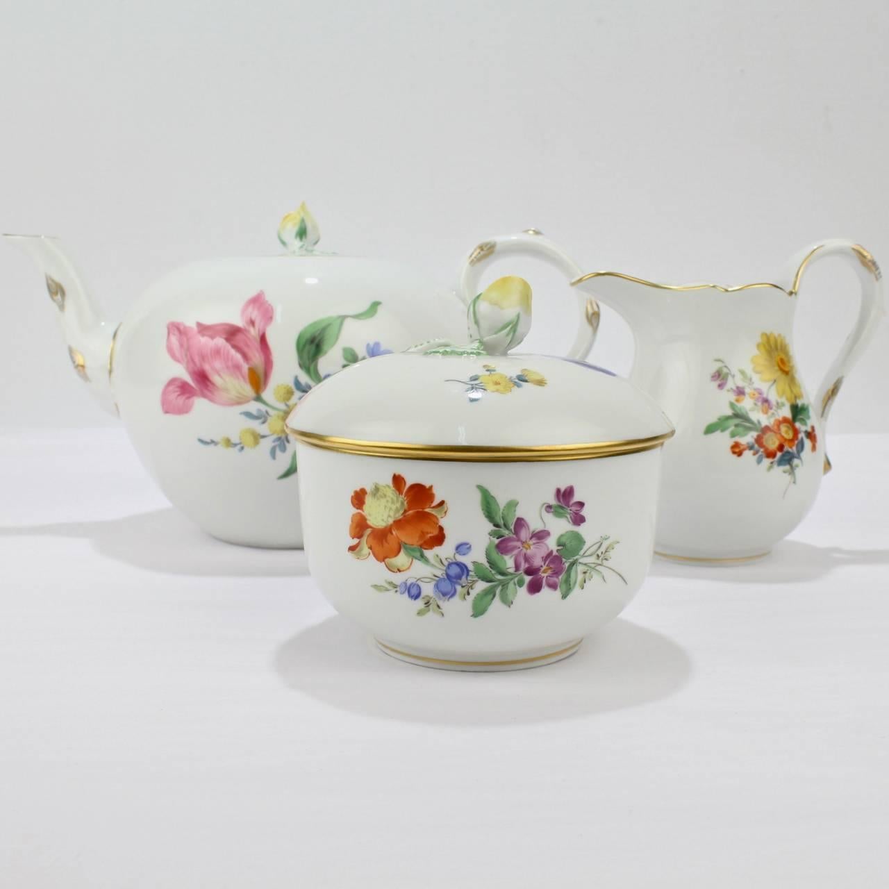 A wonderful vintage Meissen porcelain tea set.

Comprised of a creamer, sugar, and teapot.

Decorated in the Deutsche Blumen manner with polychrome floral sprays.

A picture of refinement and tradition.

Bases bear the blue crossed swords