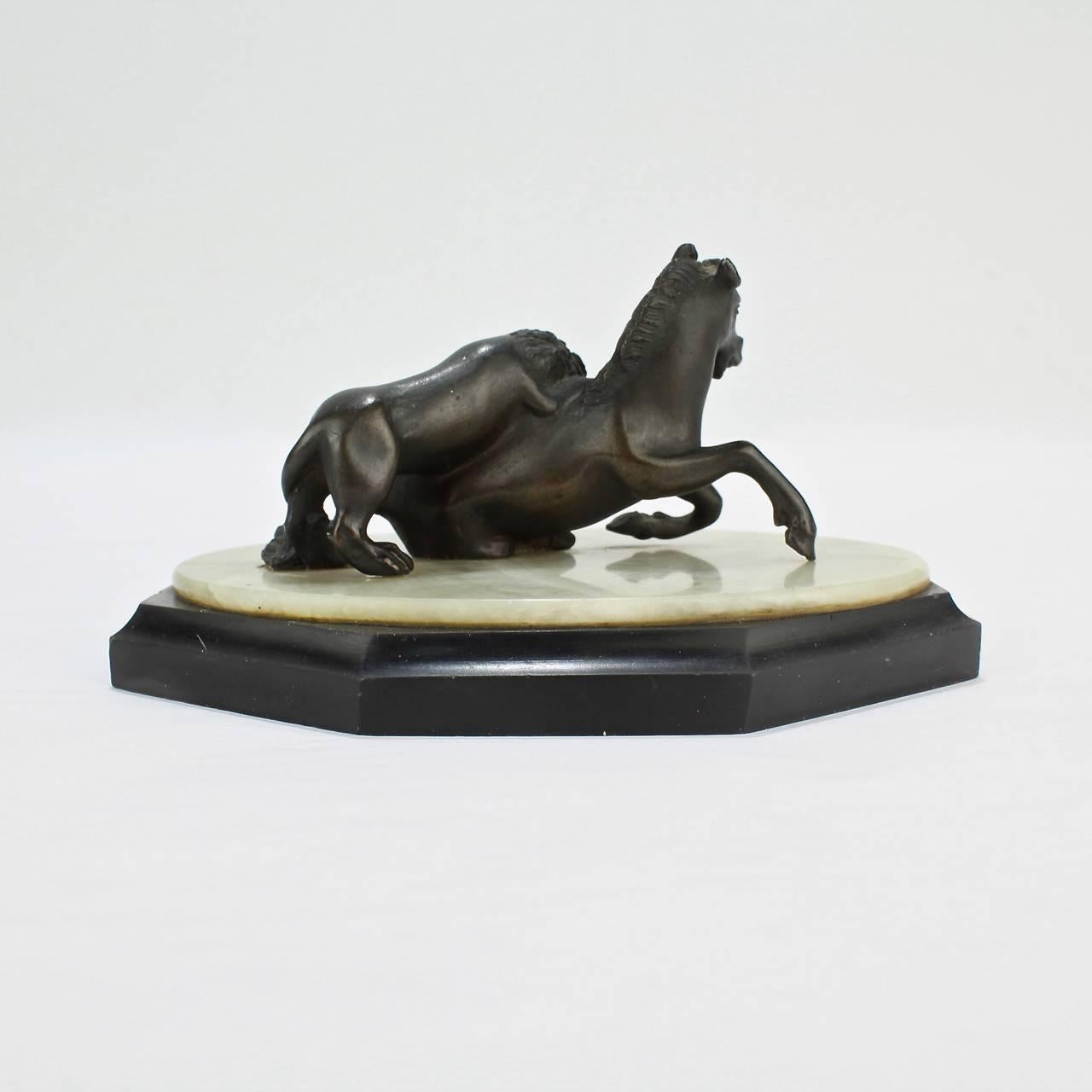 Patiné Sculpture miniature en bronze du 19ème siècle, lion attaqueant un cheval, Grand Tour en vente