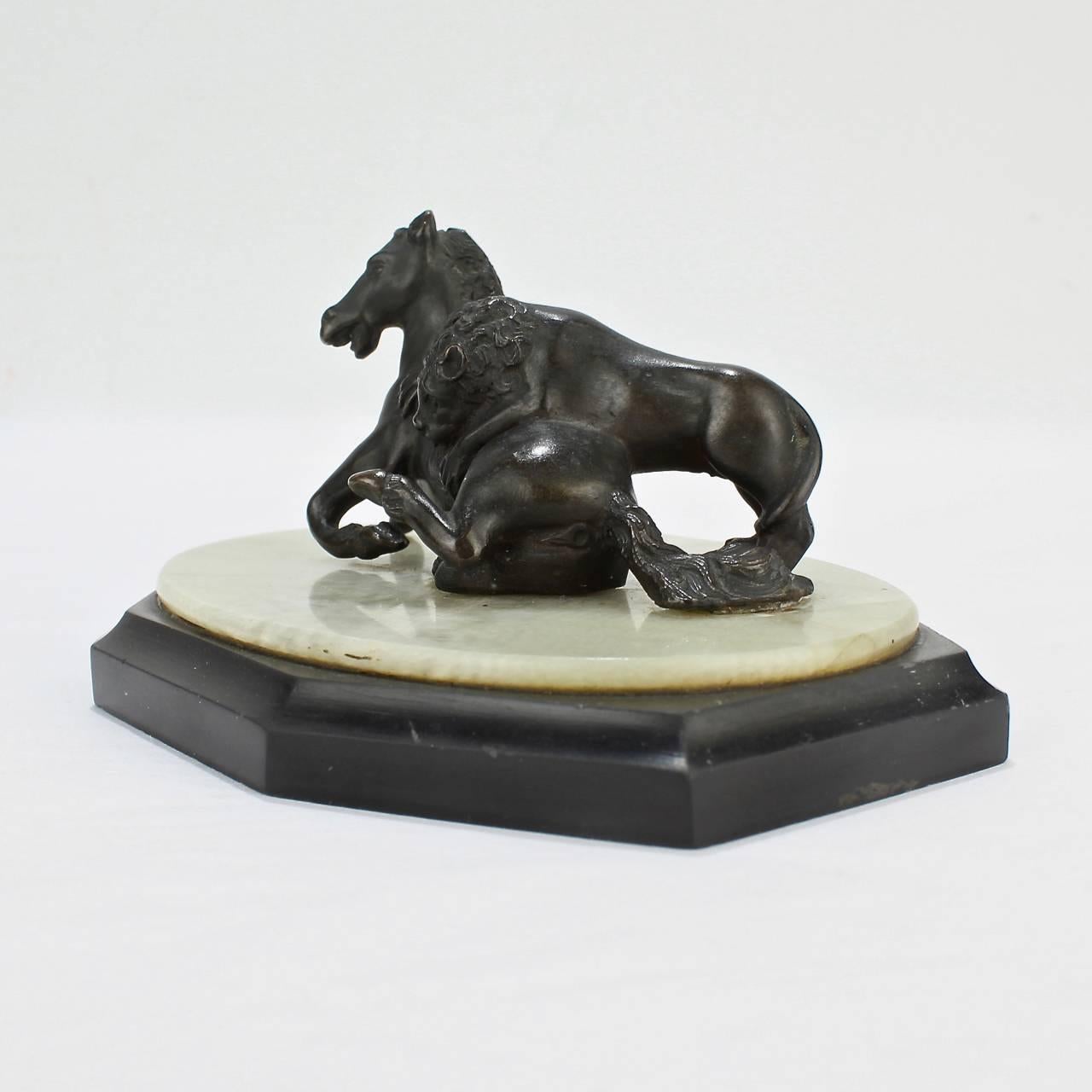 A fine 19th century Grand Tour miniature model of the Lion Attacking a Horse sculpture.

Modeled after the ancient Roman version found on Capitoline Hill.

Sized as a paperweight for the desk or perfect for shelf nestled amongst leather books