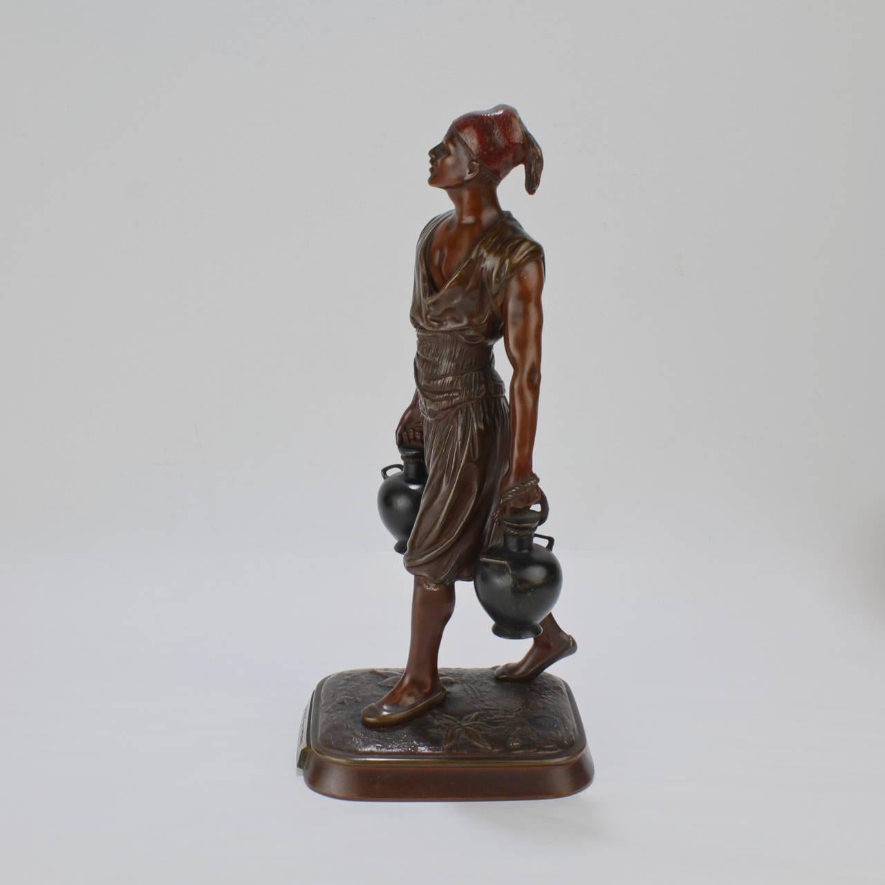 A finely cast French Orientalist sculpture after Jean-Didier Debut of a Tunisian Water Carrier cast by the Pinedo Bronzier foundry of Paris.

Entitled: Porteur d' Eau Tunisien

The bronze depicts a robust young man in mid-stride bearing two